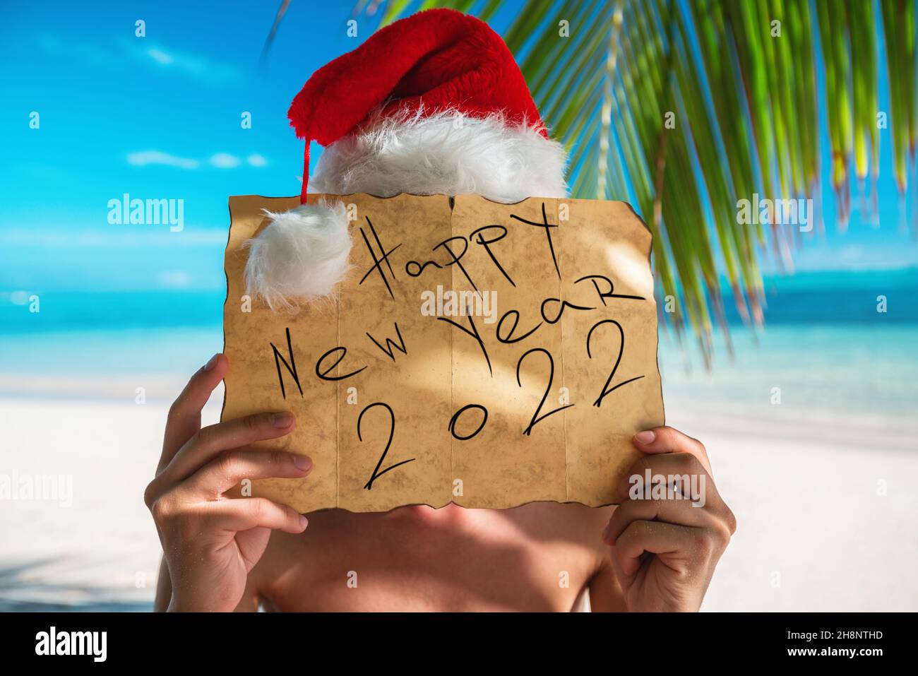 Happy new year 2022 Tourist man with Santa Claus hat relaxing on tropical island beach. Punta Cana, Dominican Republic. Stock Photo