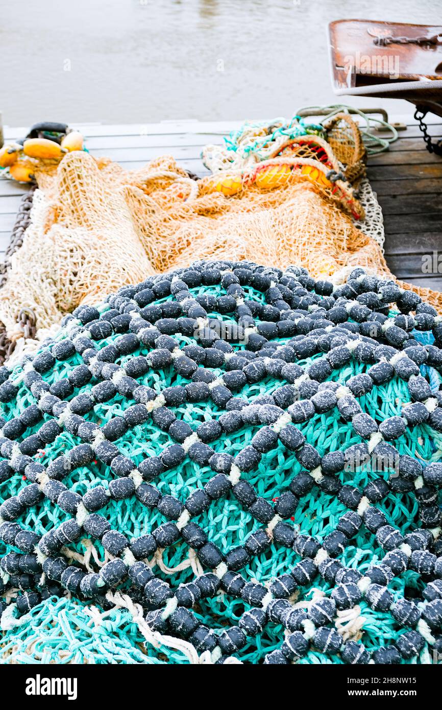 blue fishing net on a pontoon with its ropes and floats covered with ...