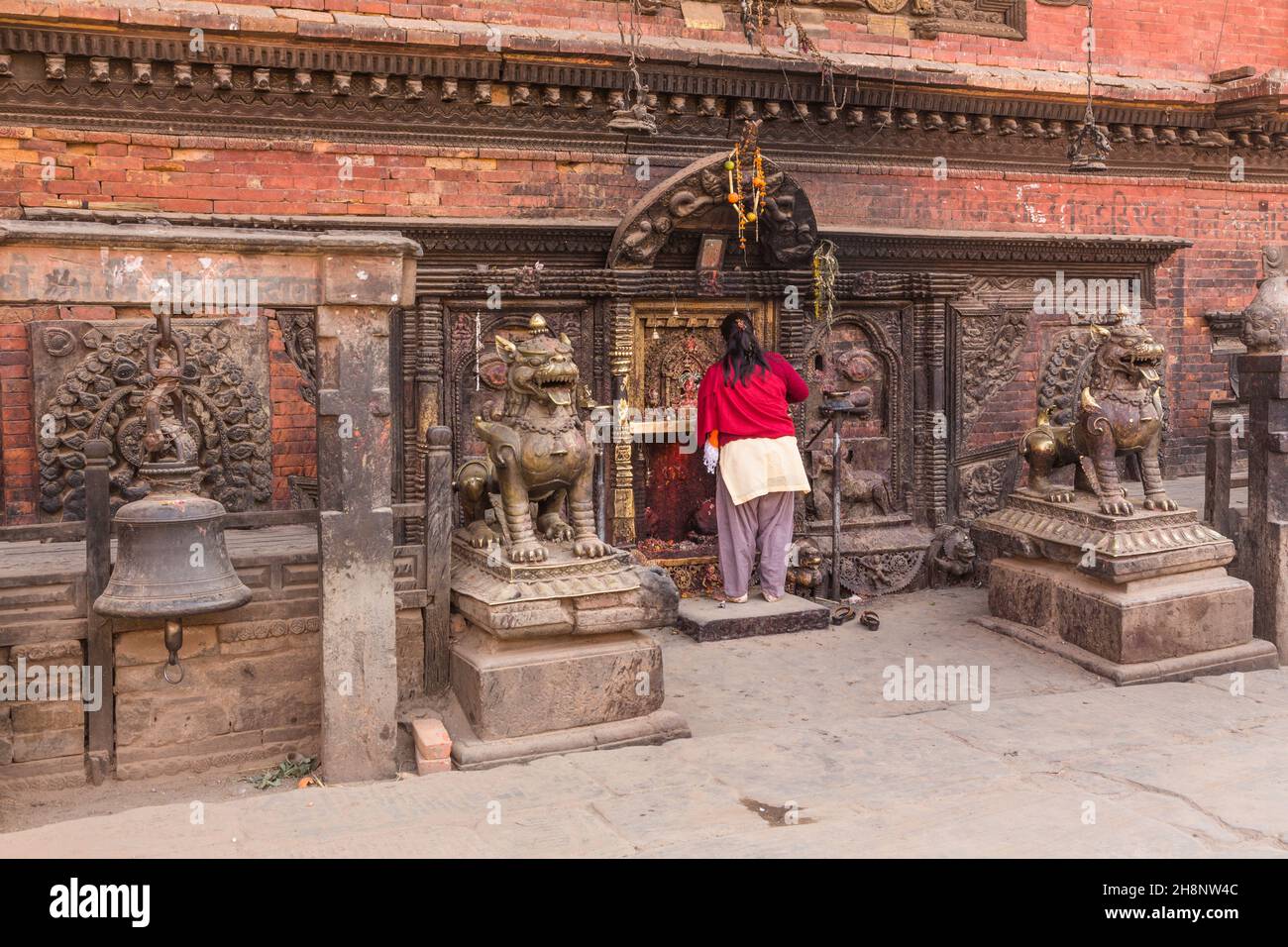A Nepali woman wearing a salwar kameez worshipping at the Bhairab Nath Temple in Bhaktapur, Nepal. Stock Photo