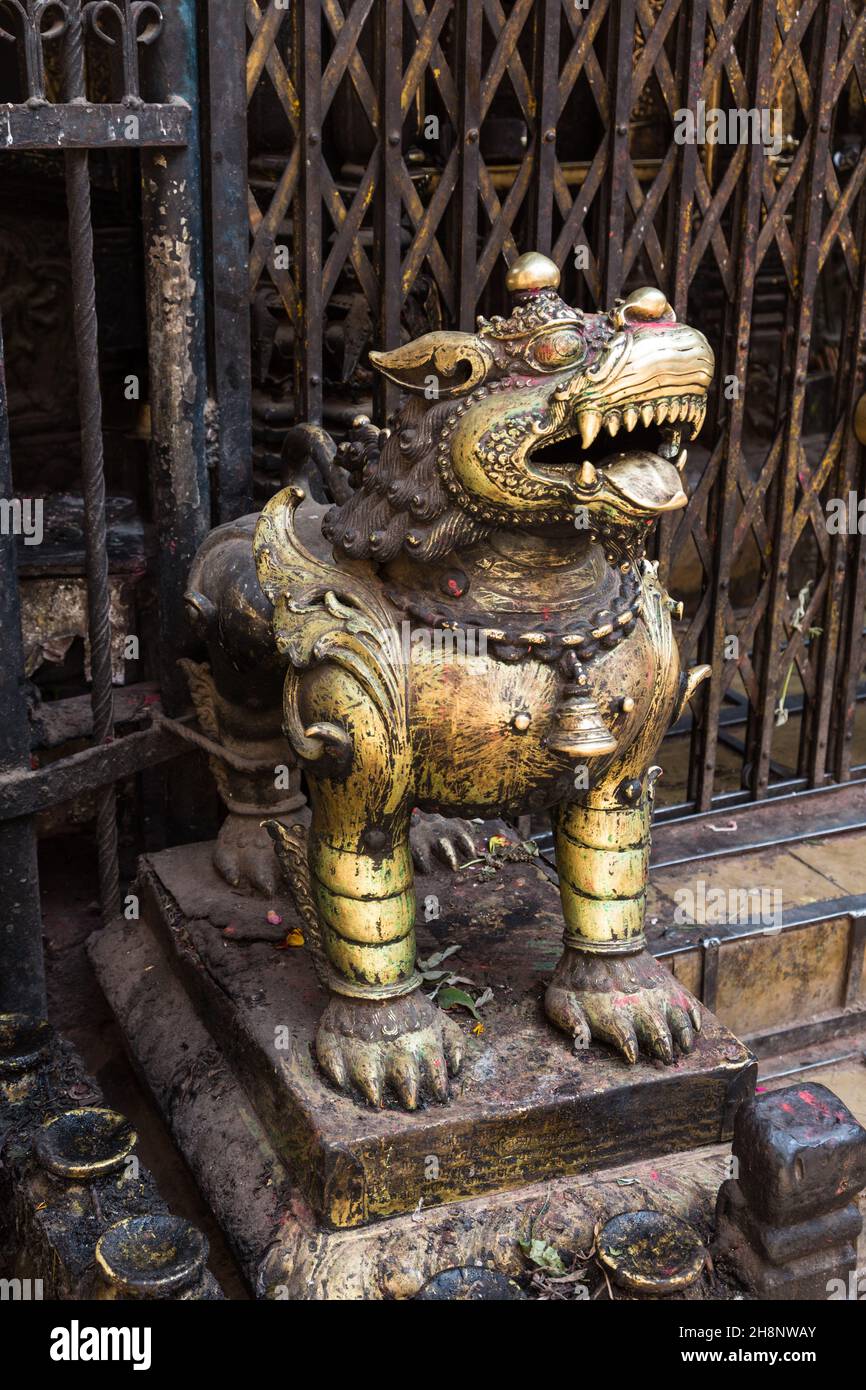 A gilded statue of a guardian lion at a Hindu temple in the medieval city of Bhaktapur, Nepal Stock Photo