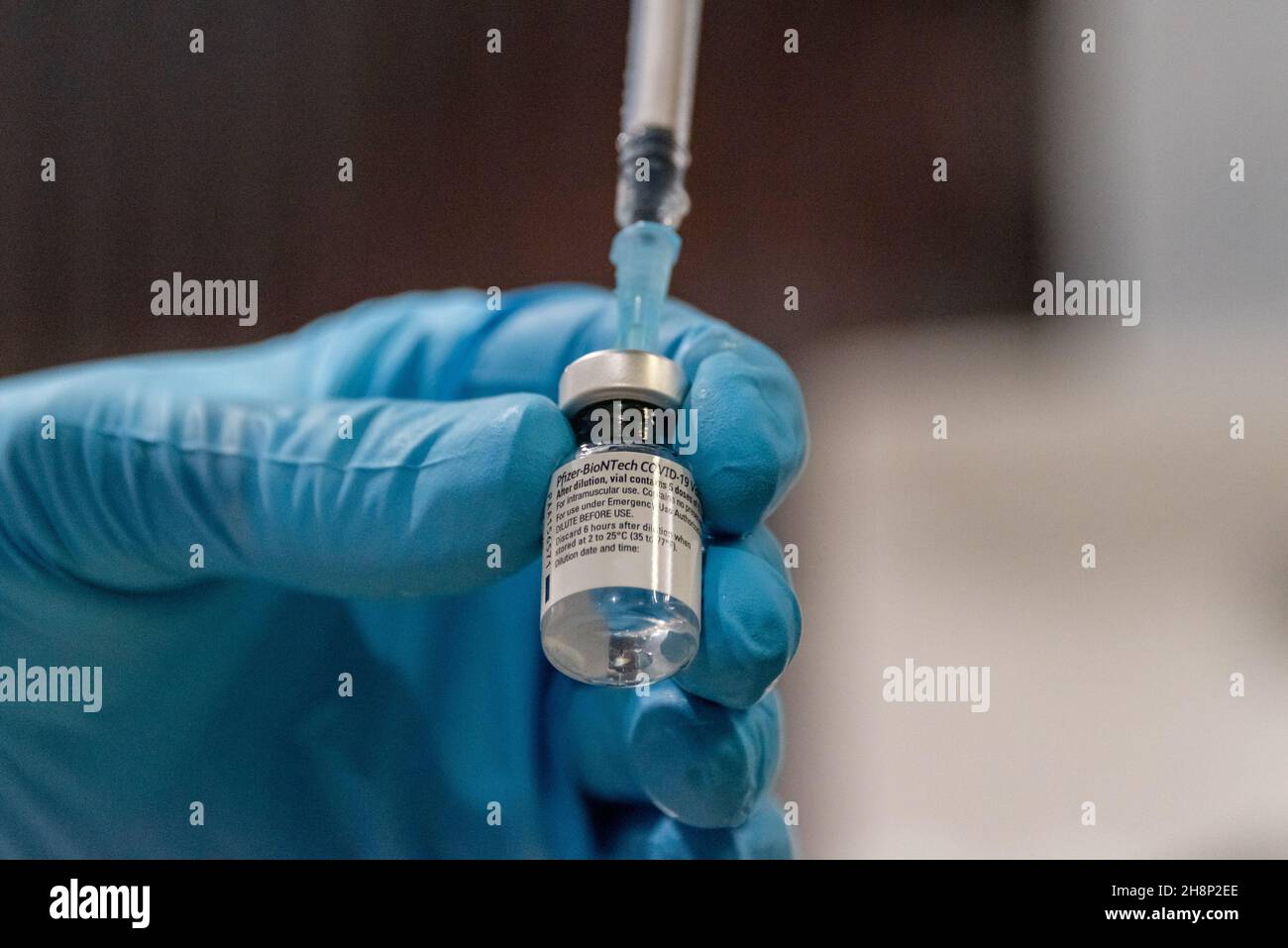 Hände mit Impfstoffampulle und Spritze beim Aufziehen des Impfstoffes gegen das Covid-19 Virus Stock Photo