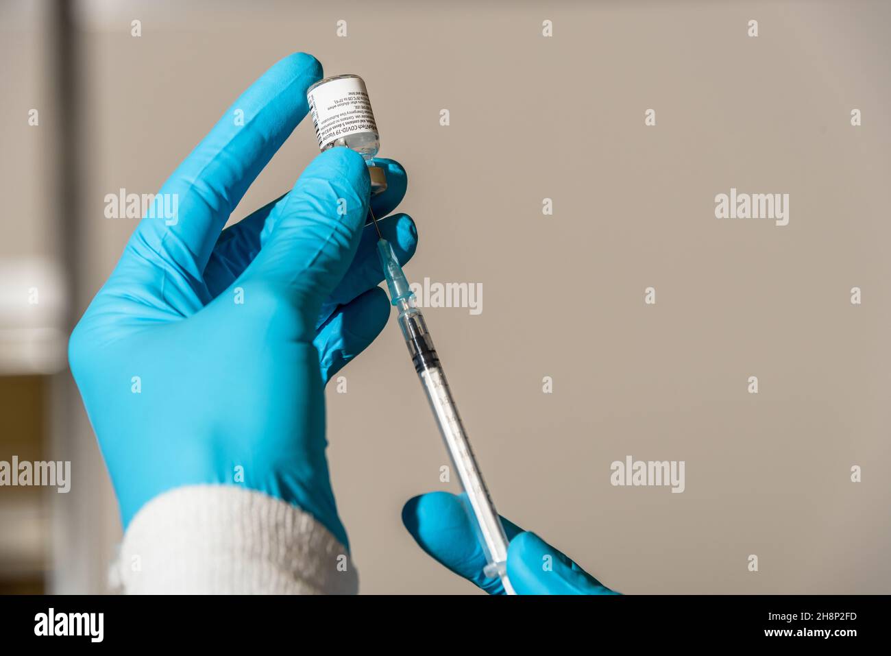 Aufziehen einer Impfdosis in eine Impfspritze zur Vorbereitung auf den Impfvorgang Stock Photo