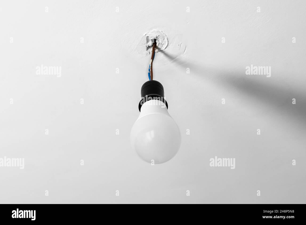 Energy saving light bulb with colored wires on the white rough ... - Energy-Saving Lighting For Apartments With Temporary Housing Needs
