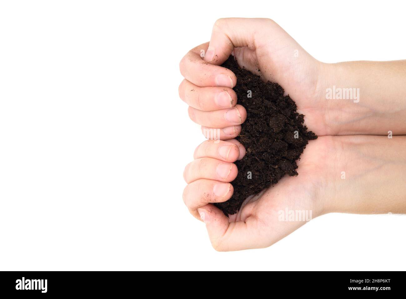 Heart symbol made of human hands holding soil isolated on white background. Stock Photo