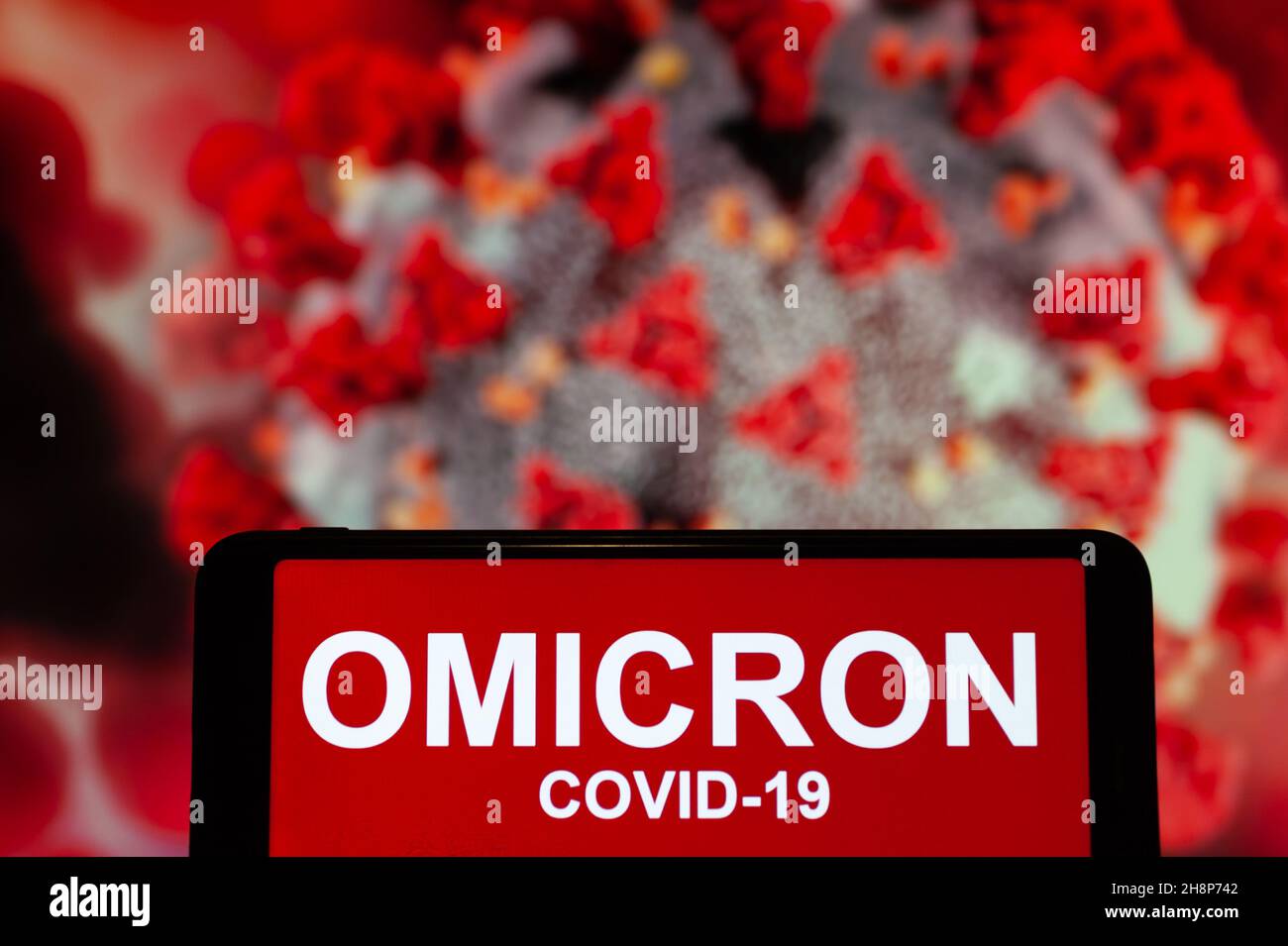 In this photo illustration, a phone screen shows a text that says Omicron COVID-19. Stock Photo