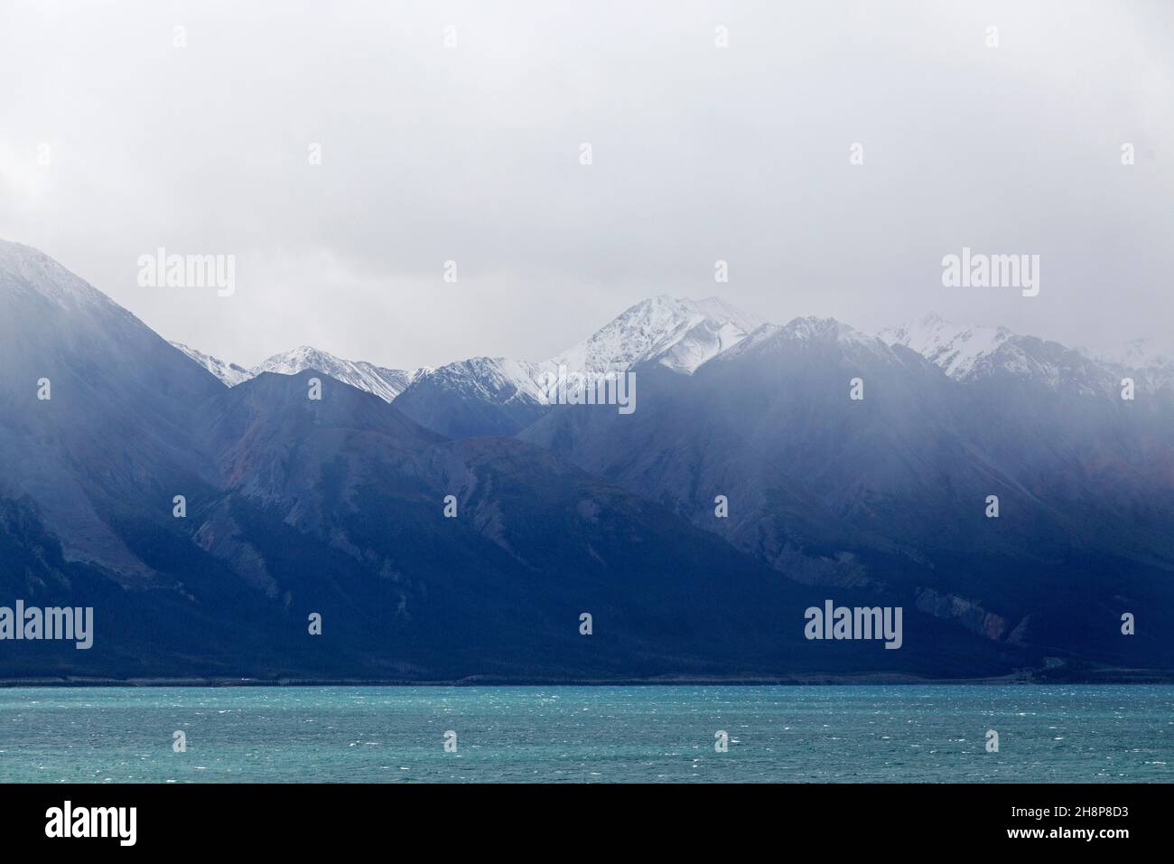 Snow-capped mountains rise above Kluane Lake in the Yukon, Canada. Stock Photo