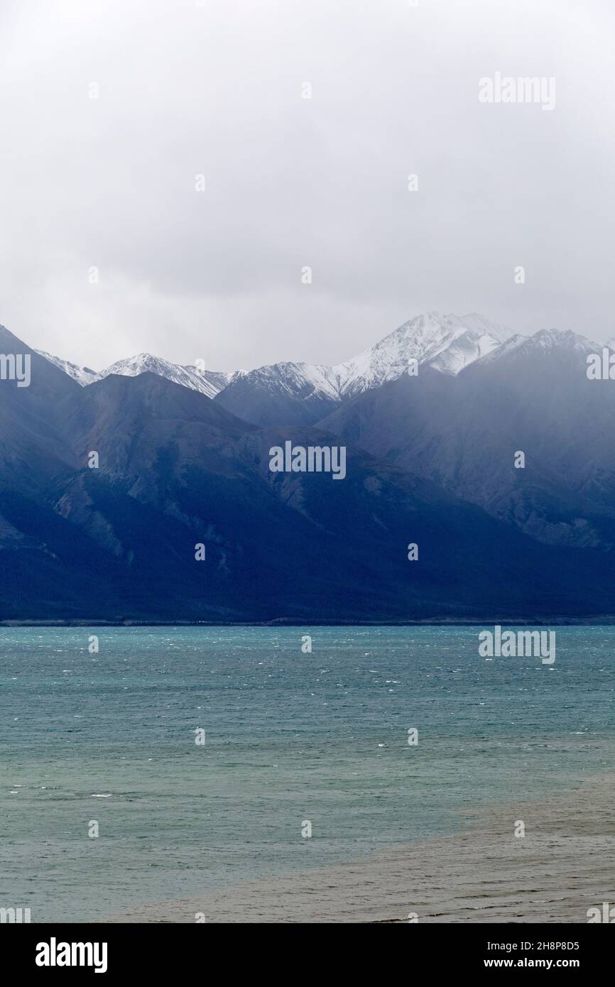 Mist and Snow-capped mountains rise above Kluane Lake in the Yukon, Canada. Stock Photo