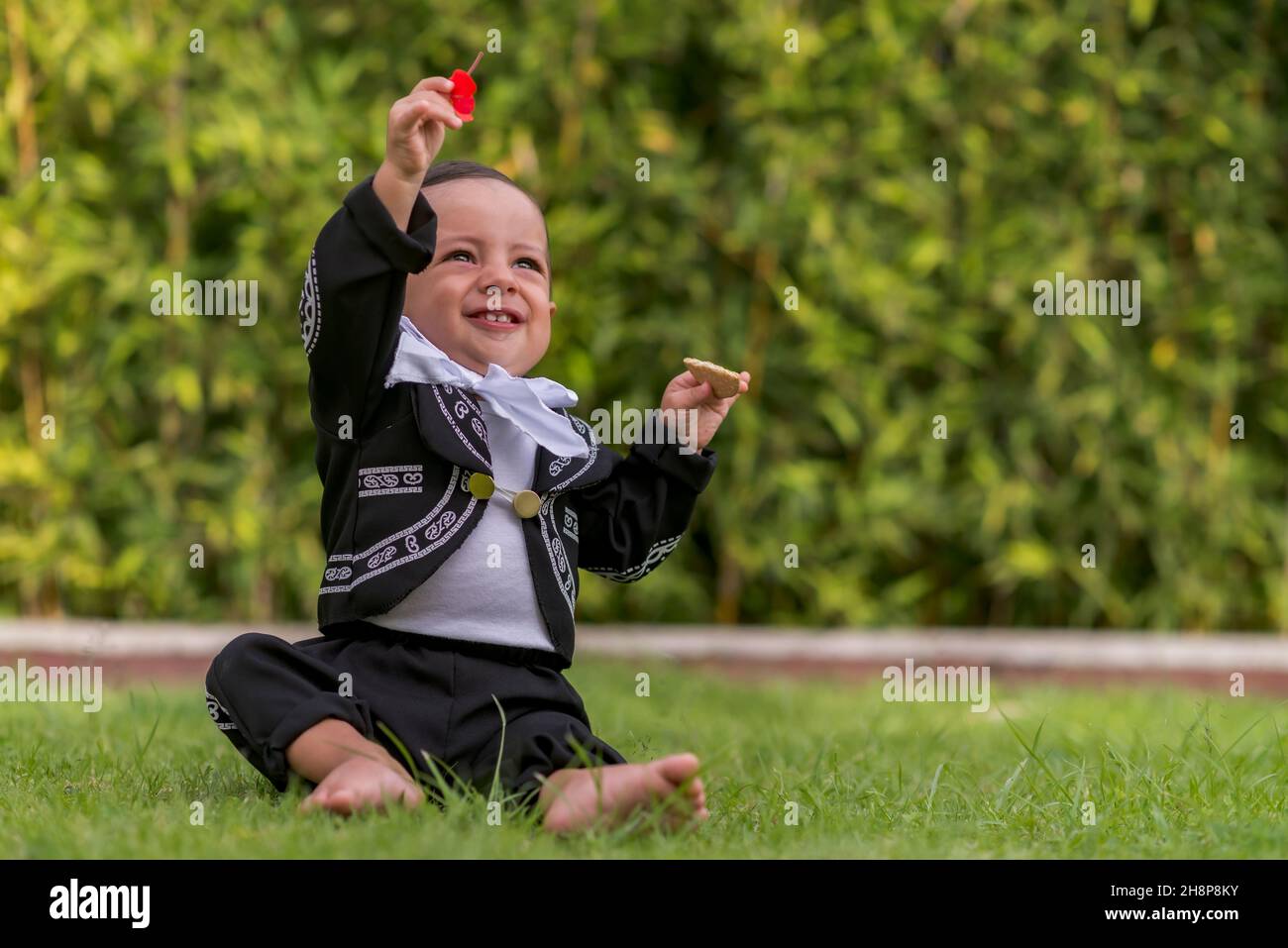 Small latin baby boy with a mariachi costume happy smilling having fun Stock Photo