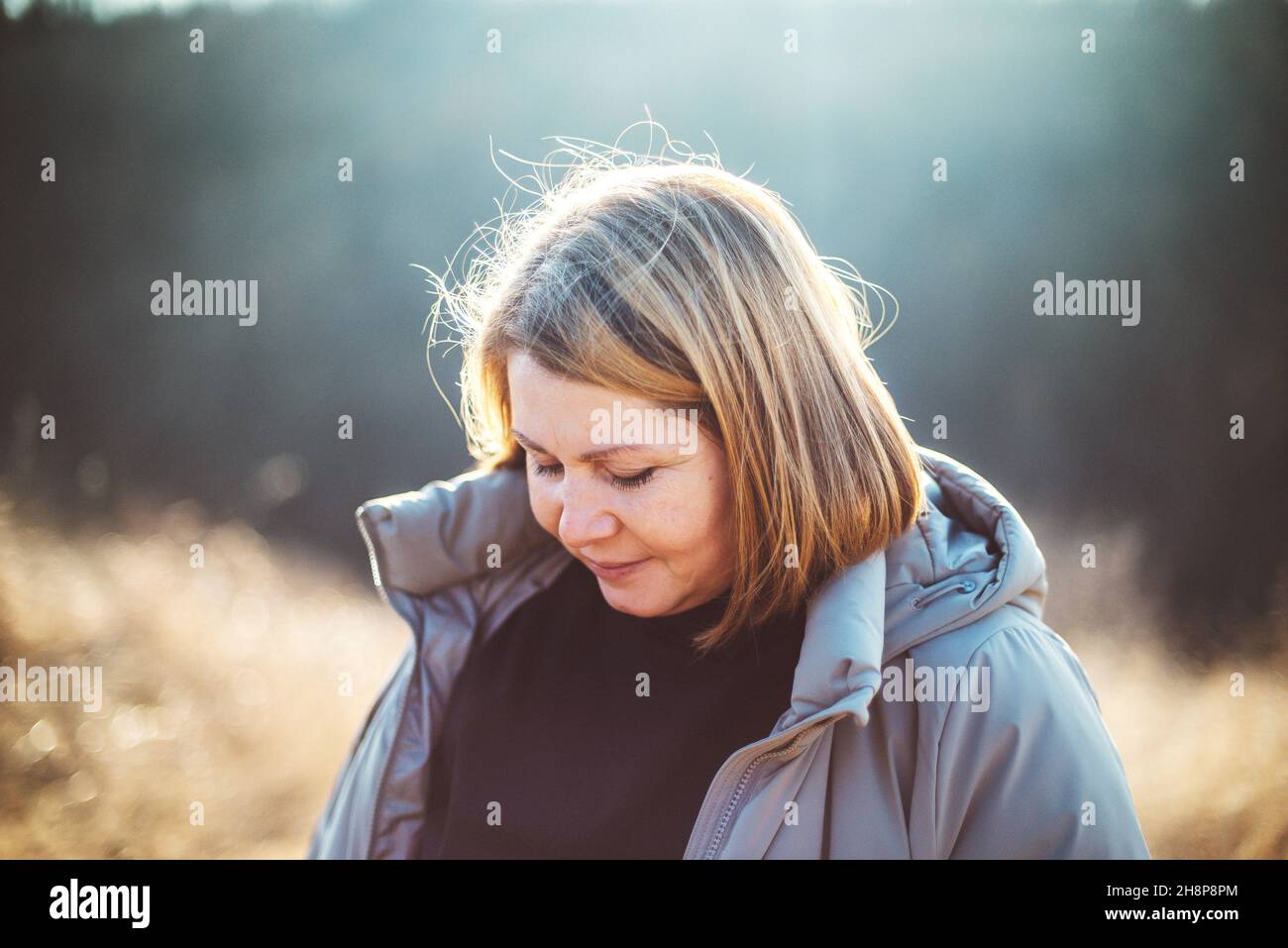 Portrait of adult woman standing in field sunset Stock Photo - Alamy