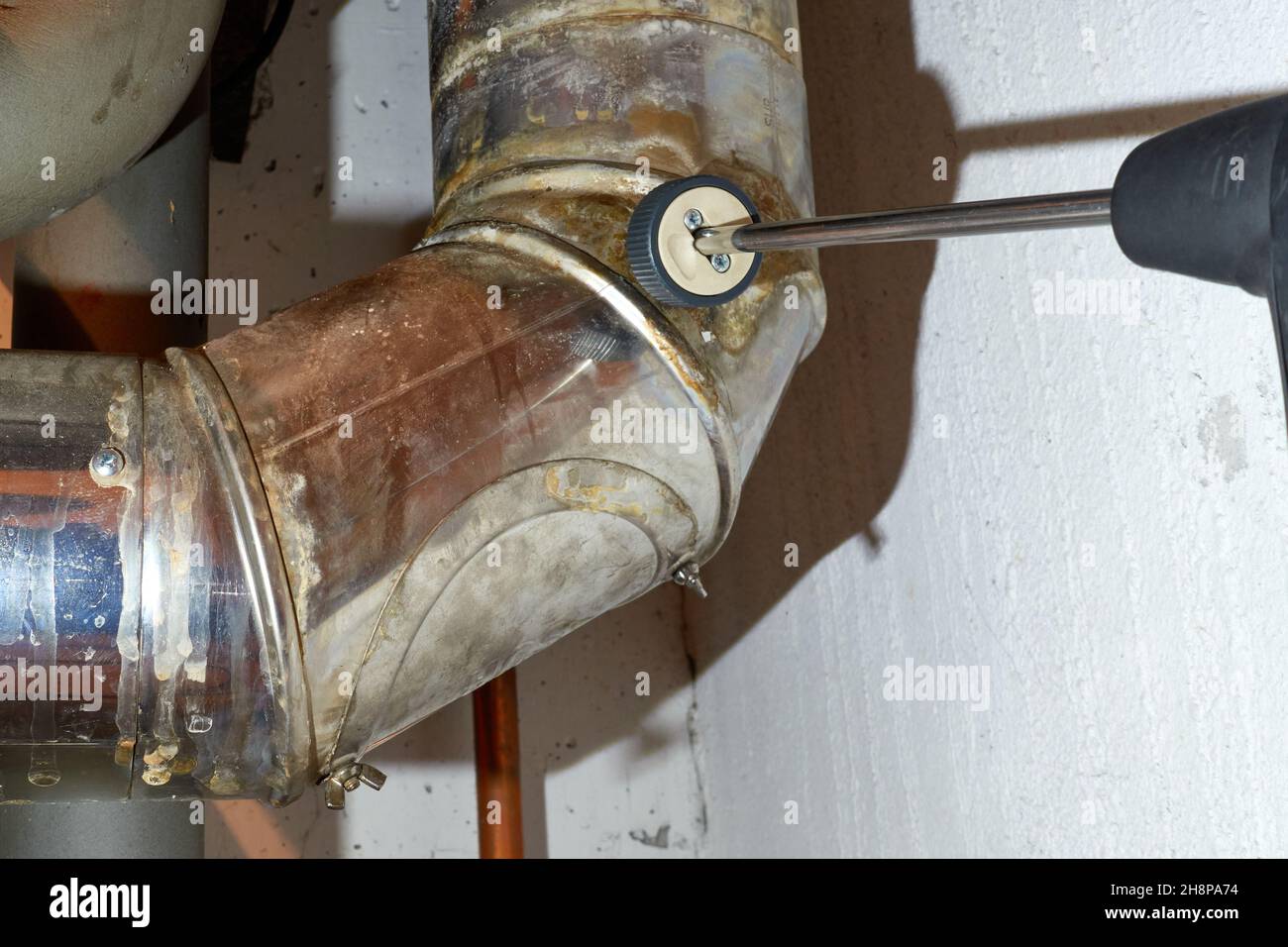 The pollutant content is determined at the heating pipe with a probe of a measuring device. (Soot and carbon monoxide) Stock Photo