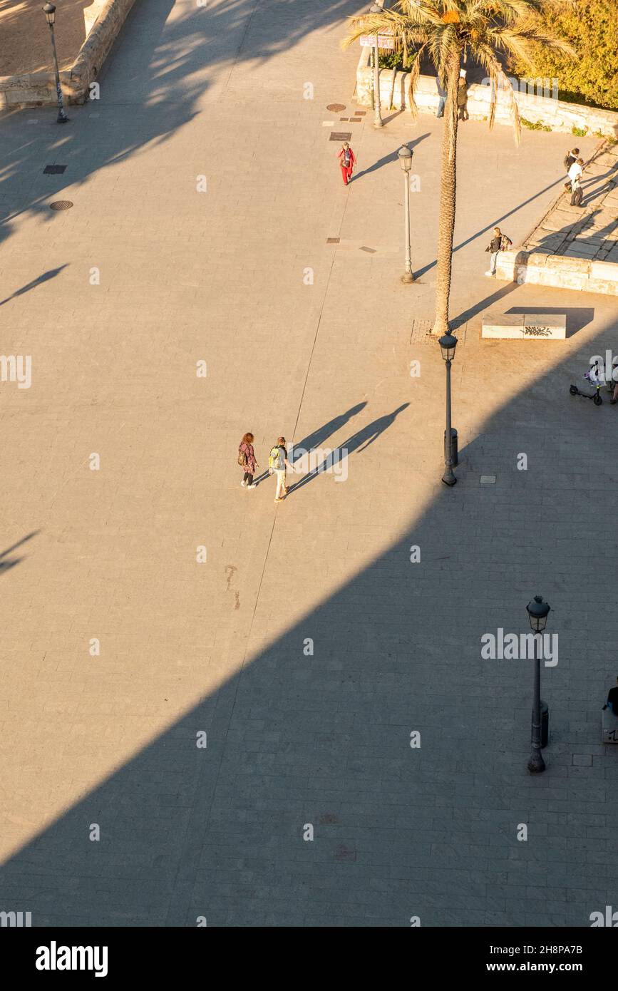 People walking with long shadows Stock Photo - Alamy