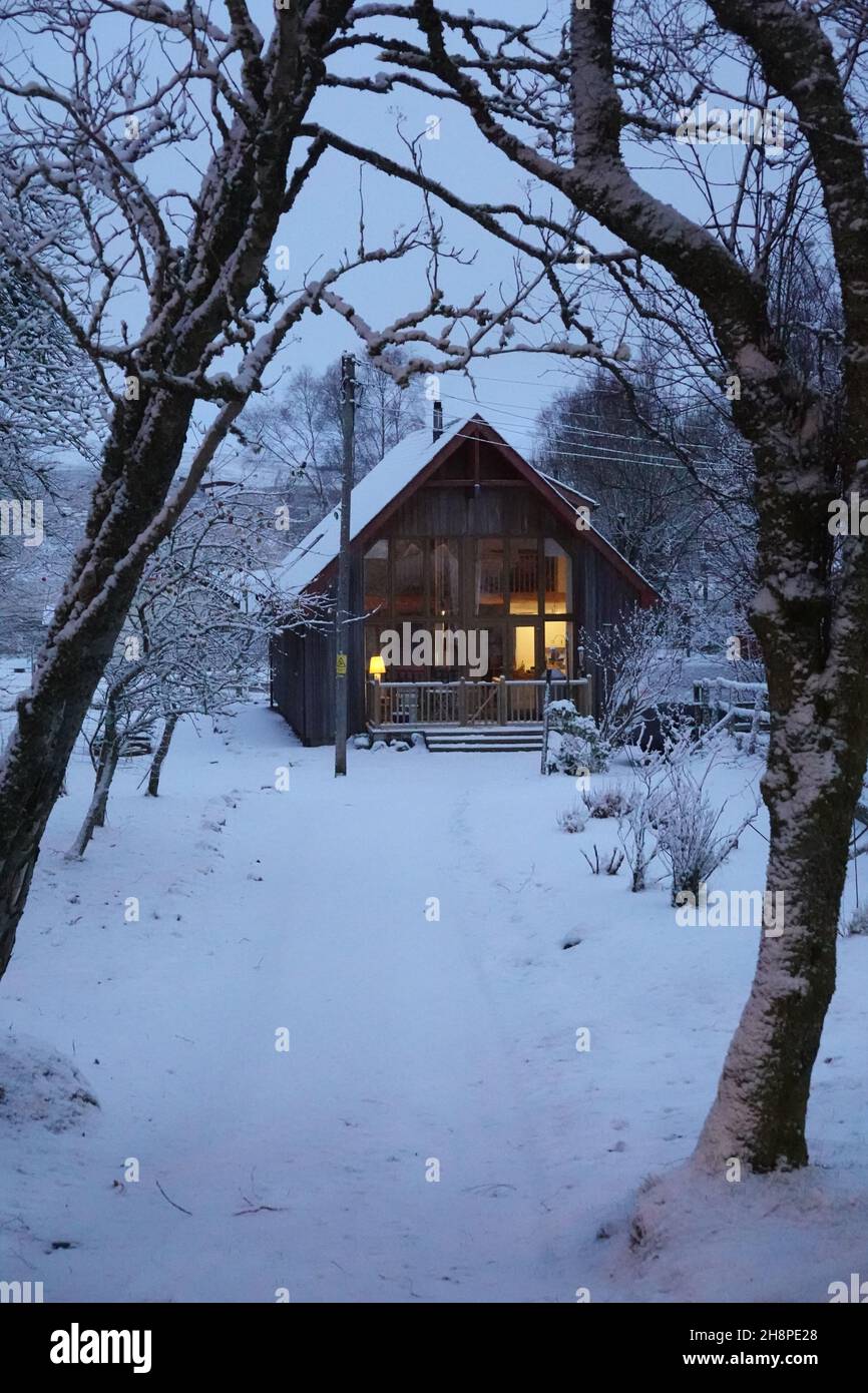 Wooden house set in a snowy landscape framed by trees Stock Photo - Alamy
