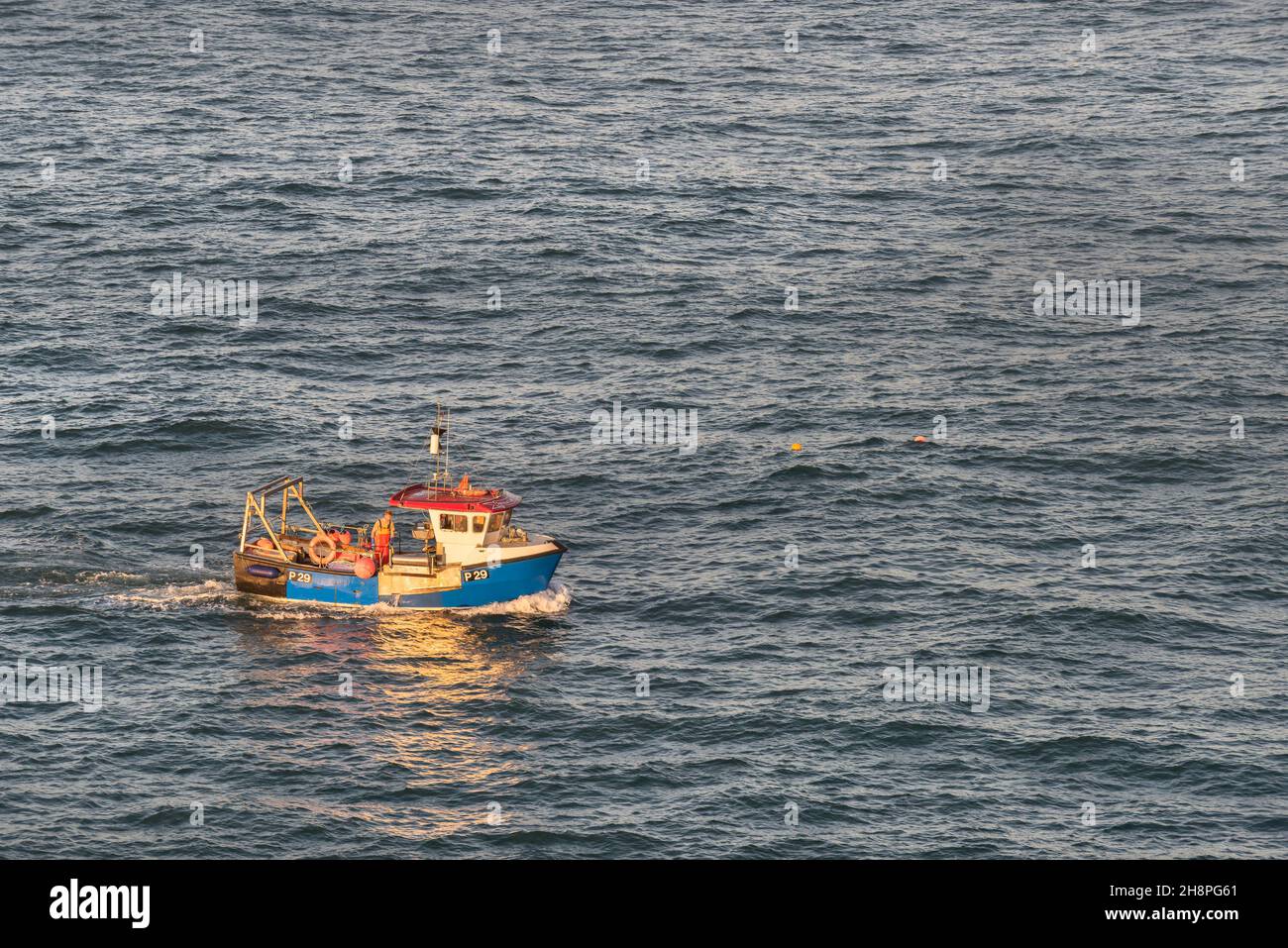 Fishing boat P29 Spirited Lady working as the sun sets over Newquay Bay on the North Cornwall coast. Stock Photo