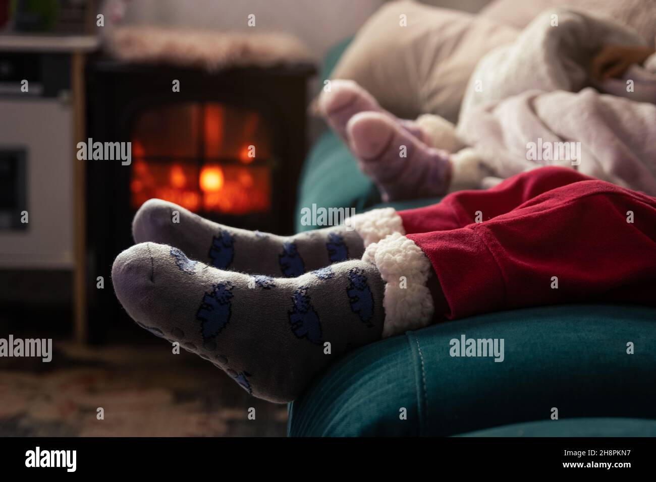 Children,s feet with thick Christmas socks in front of the fireplace Stock Photo