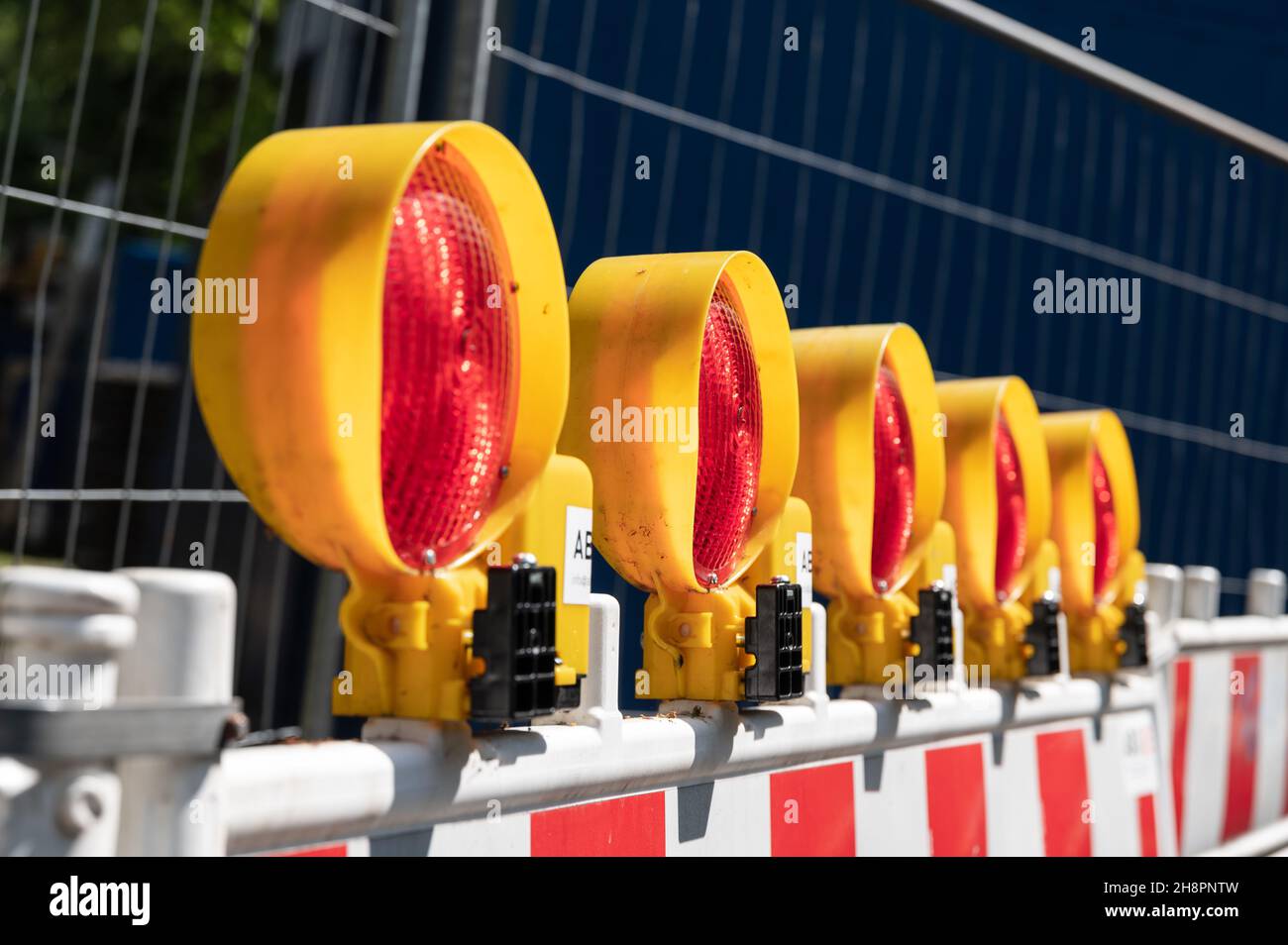 five redcolored hazard lights on a construction site barrier Stock