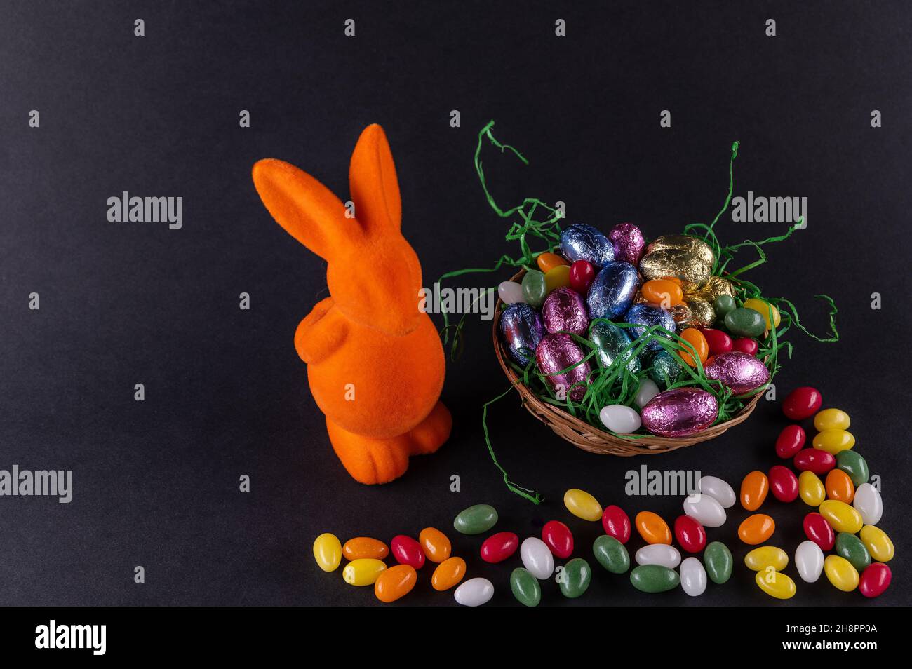 Orange bunny with a filled Easter basket and sweet eggs Stock Photo
