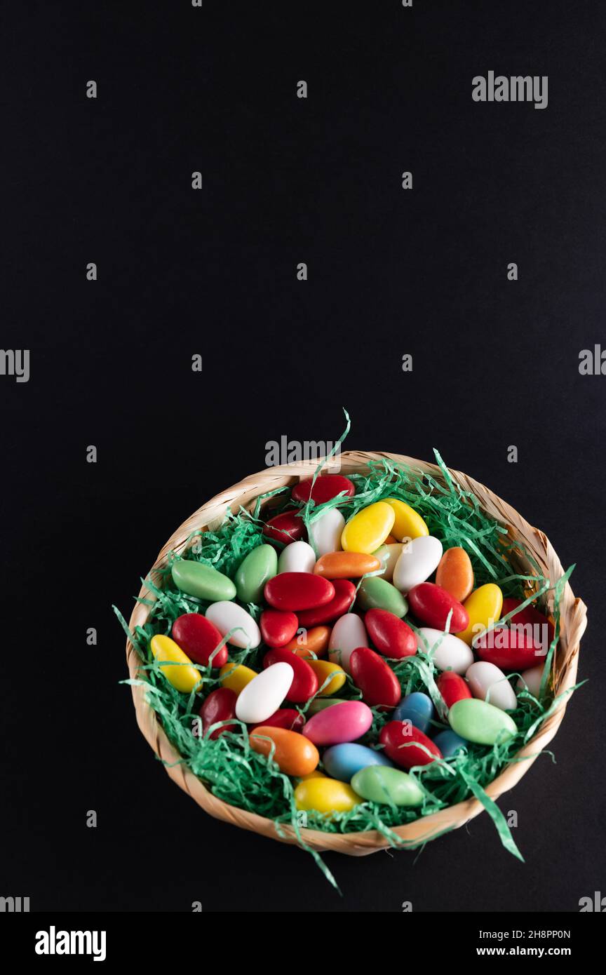 a filled Easter basket with sweet eggs on a dark background Stock Photo