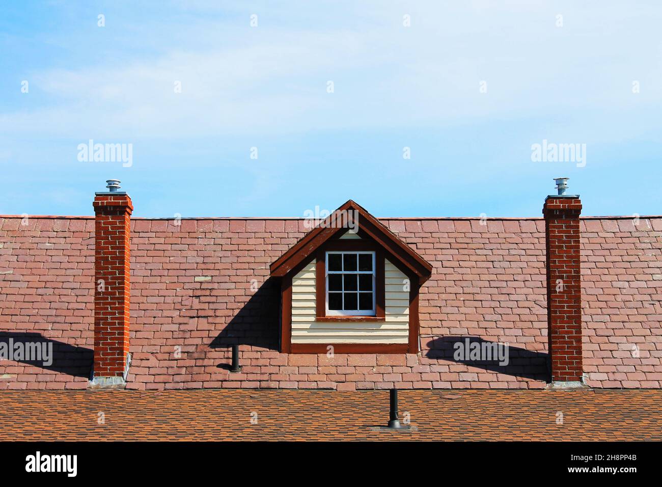Close-up of a dormer window between two chimneys Stock Photo