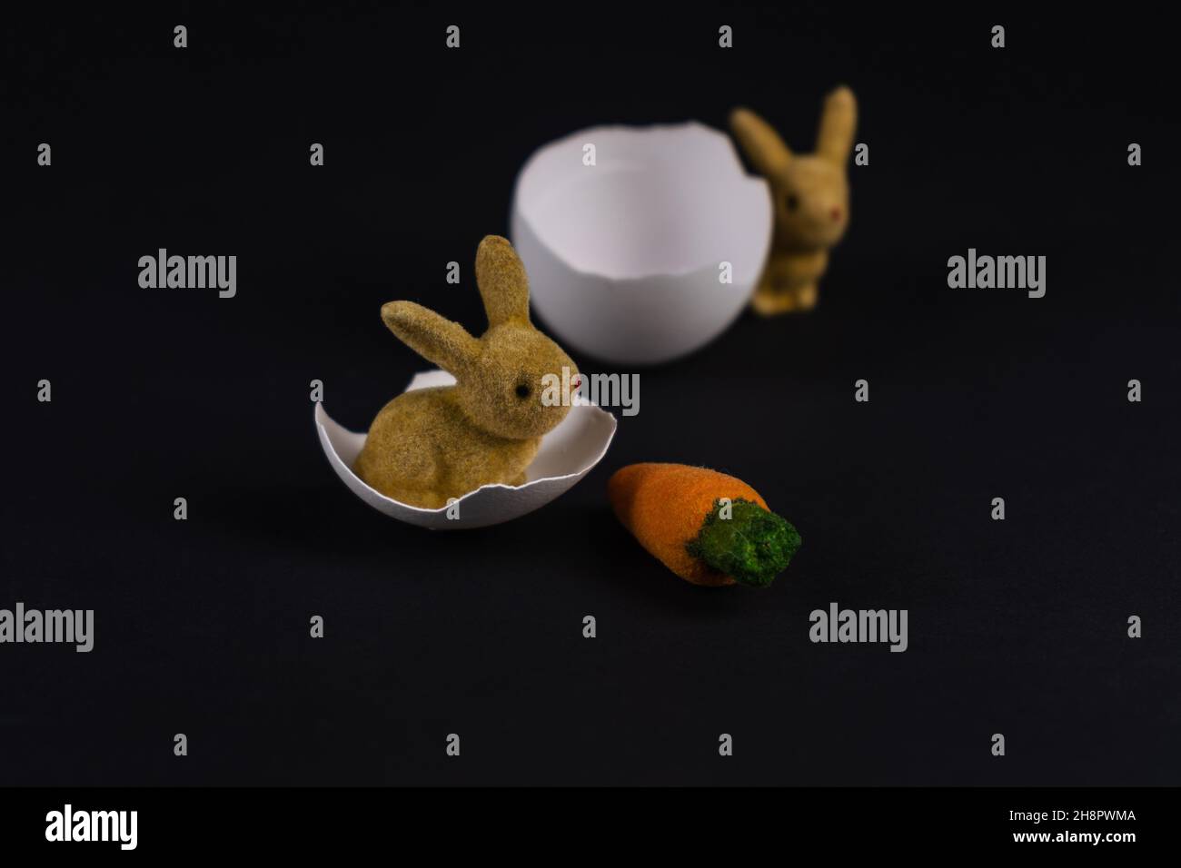 two decorative Easter bunnies with eggshells and a carrot Stock Photo
