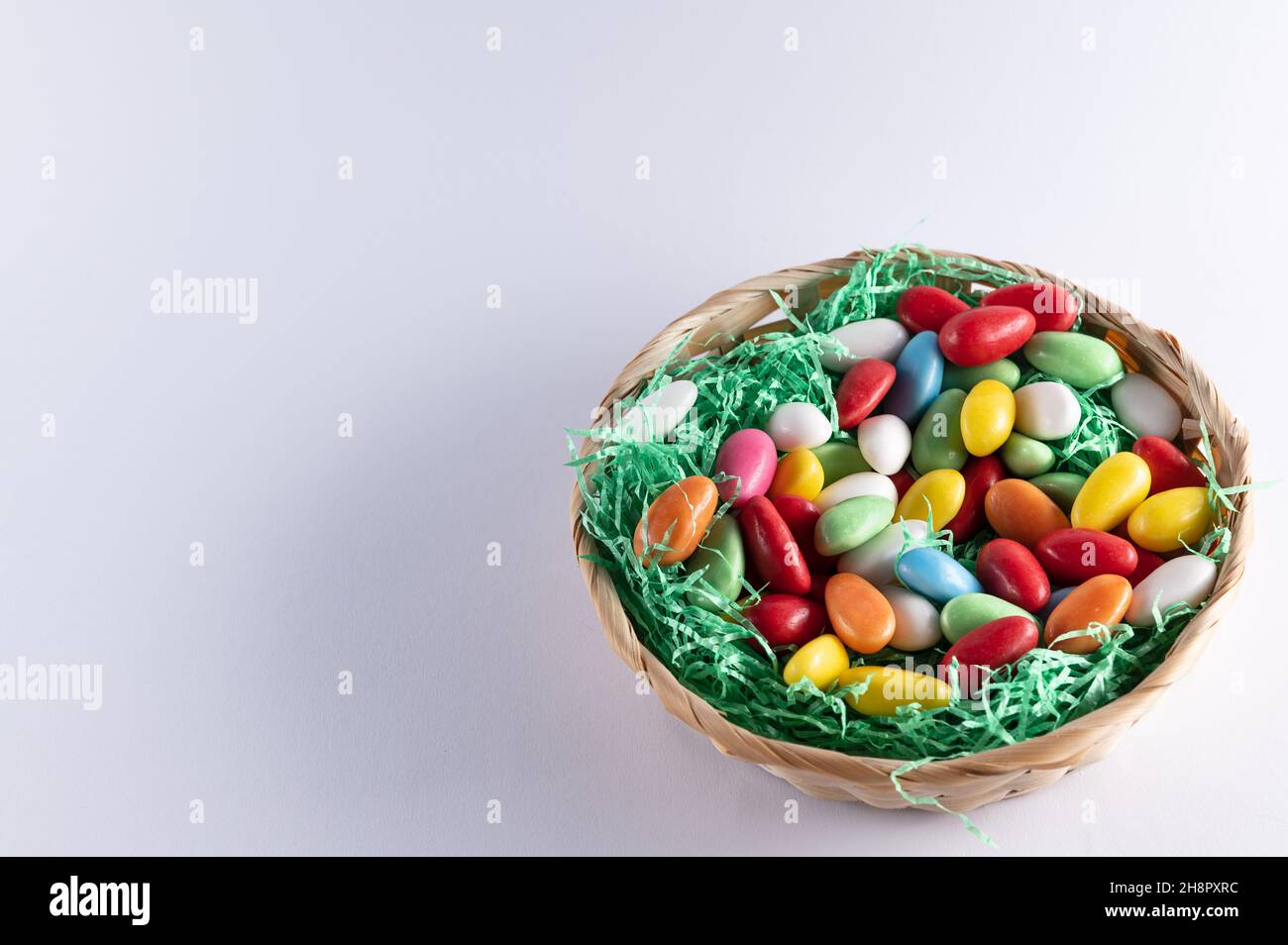 a filled Easter basket with sweet eggs on a light background Stock Photo