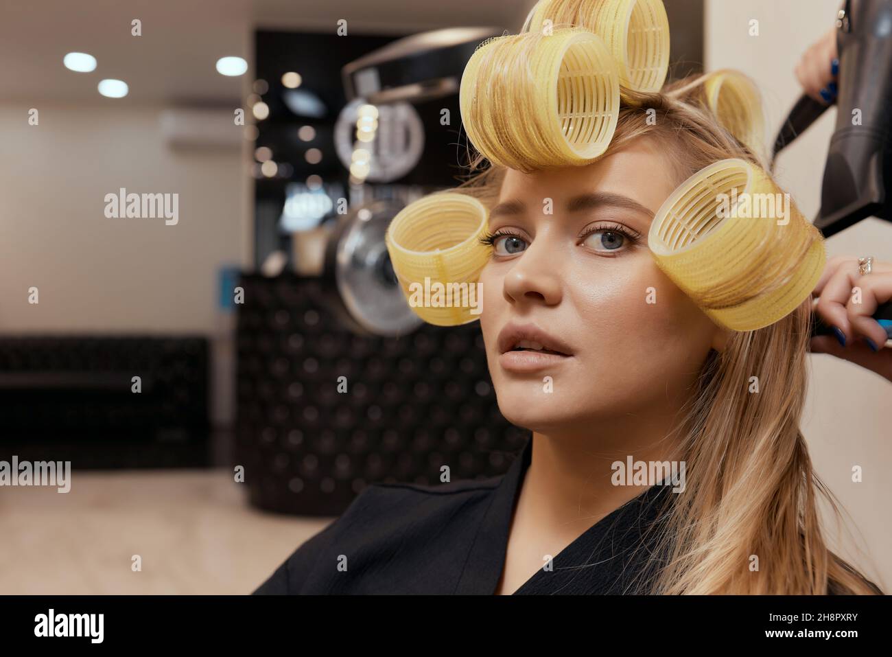 Drying blond hair with hair dryer and round brush Stock Photo - Alamy