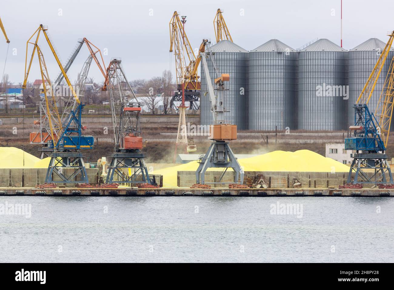 Huge stockpile of industrial sulfur that will be shipped around world. Industrial Sulfur Stockyard and Pile. Huge stockpile of sulfur in sea port at b Stock Photo