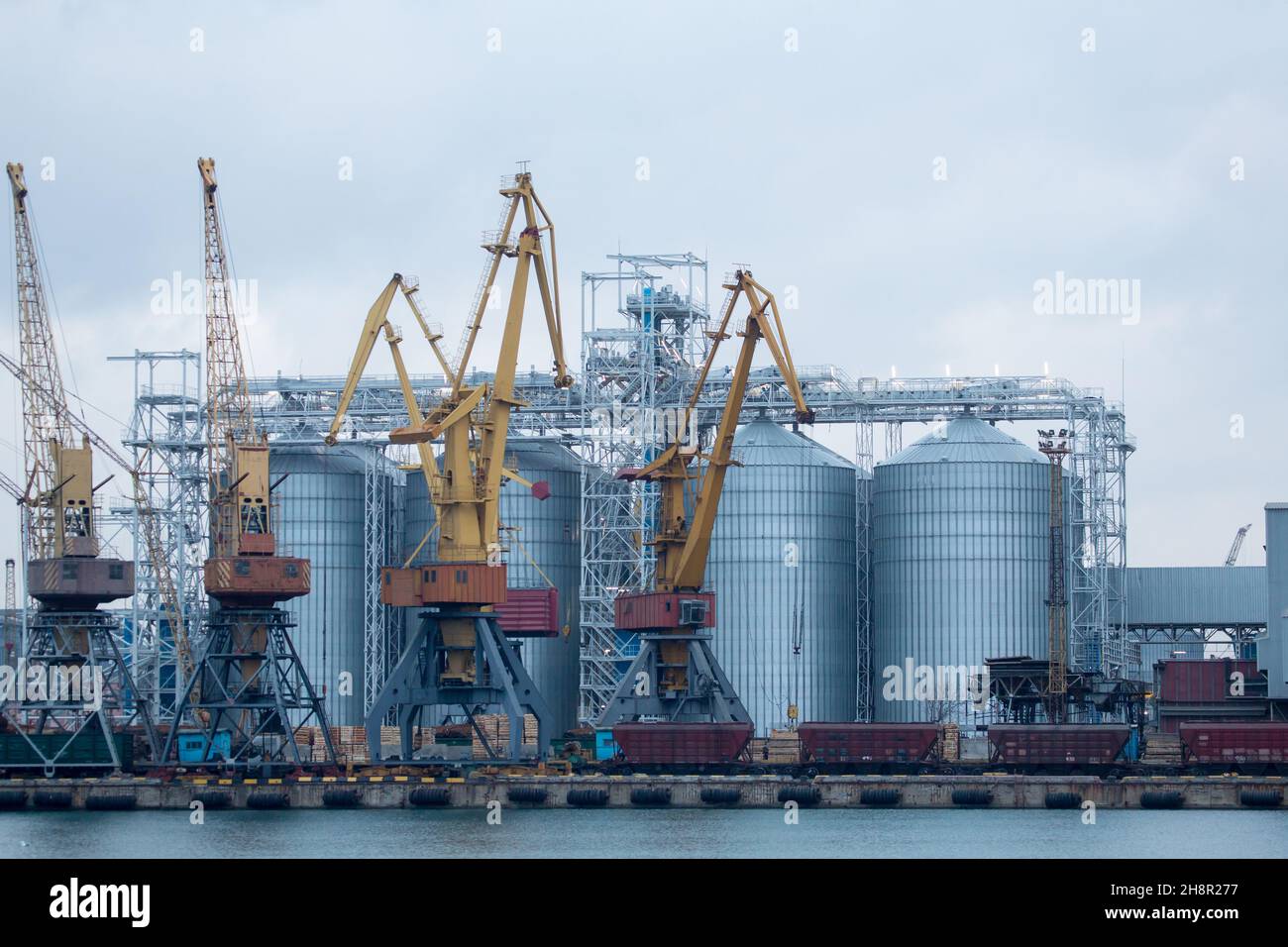 Railroad cars in port for loading unloading. Port cranes unload, load ...