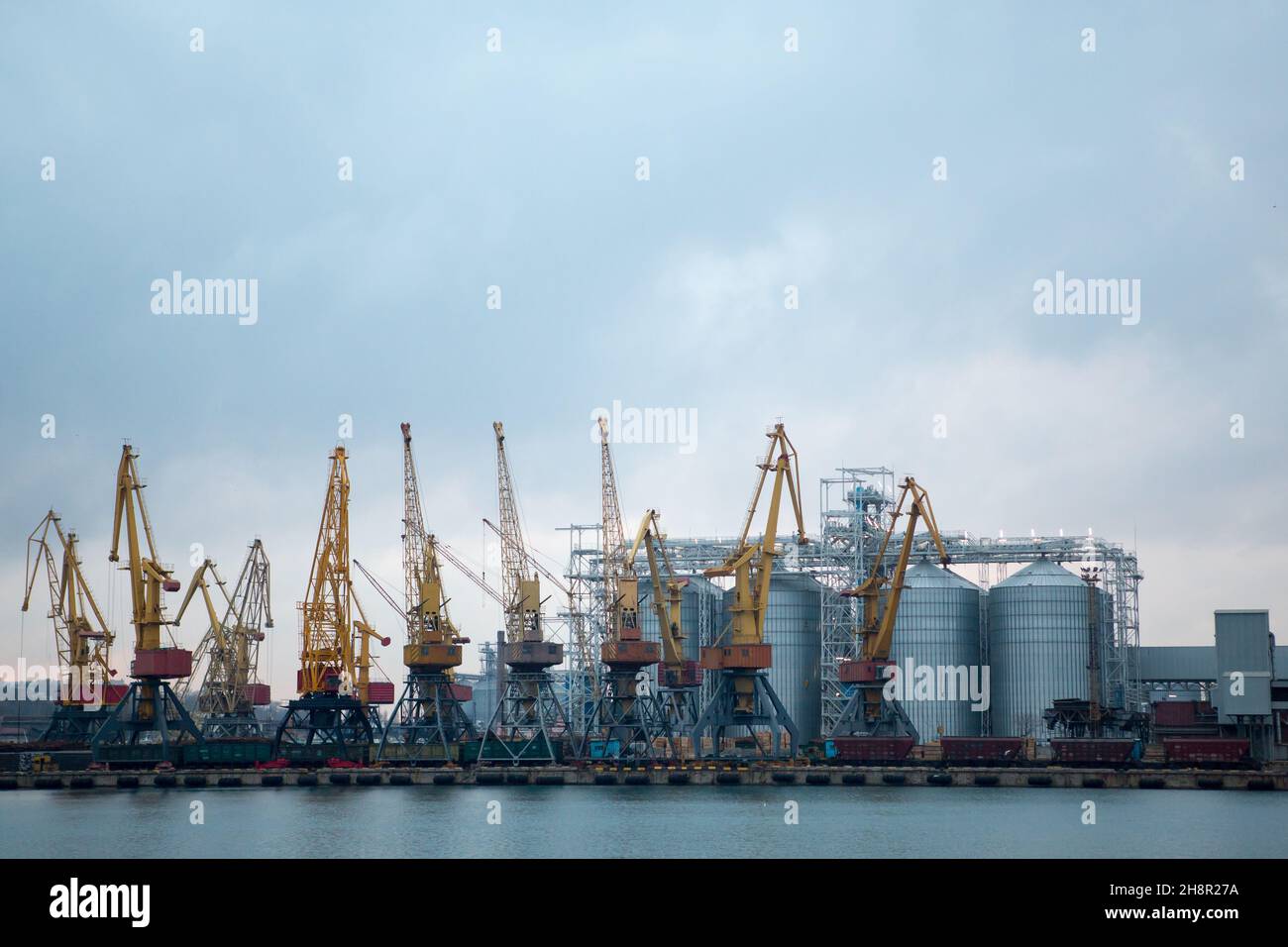 Railroad cars in port for loading unloading. Port cranes unload, load ...