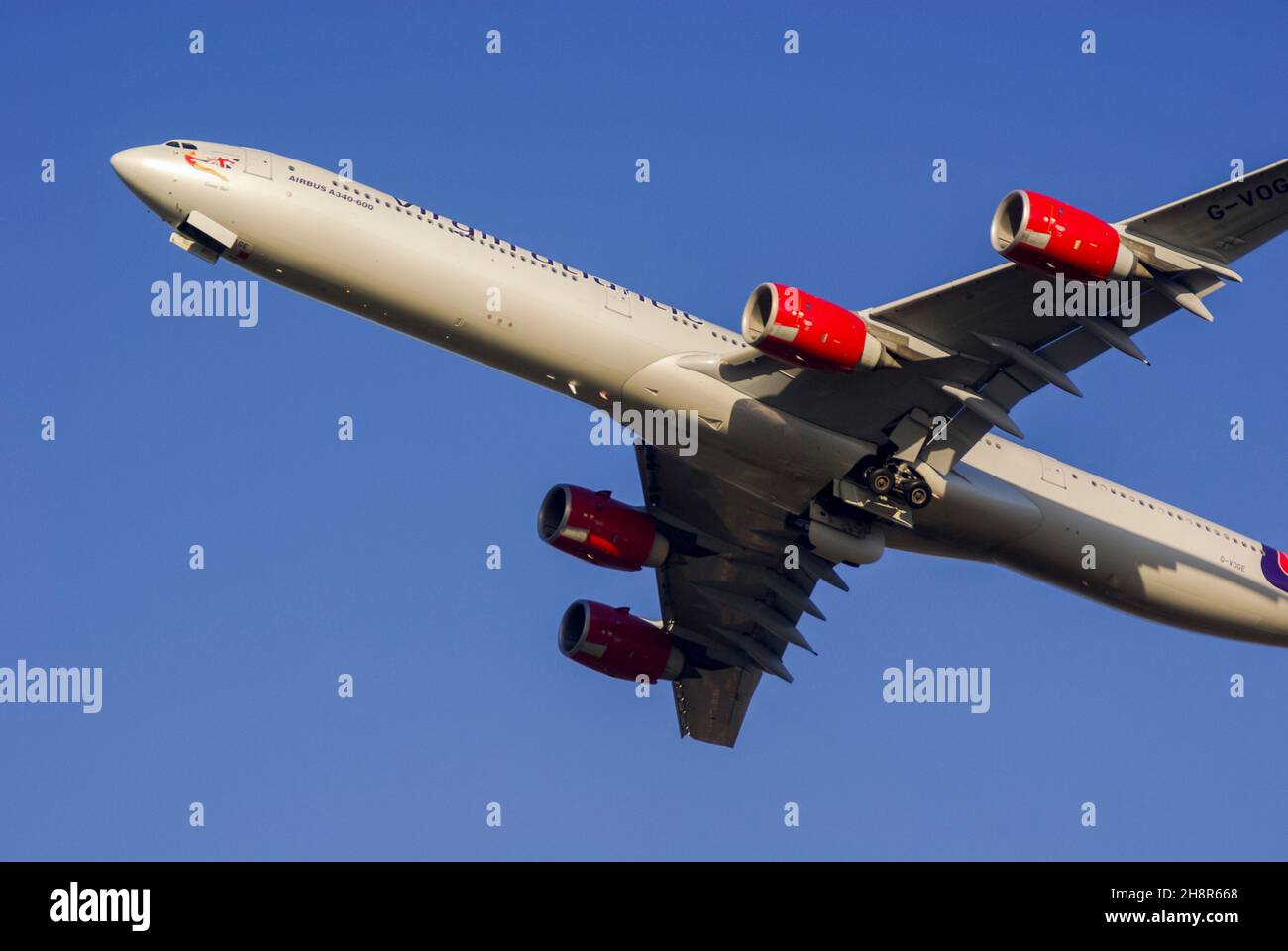 Virgin Atlantic Airways Airbus A340 jet airliner plane G-VOGE taking off from London Heathrow Airport, UK. Named Cover Girl. Departing in blue sky Stock Photo