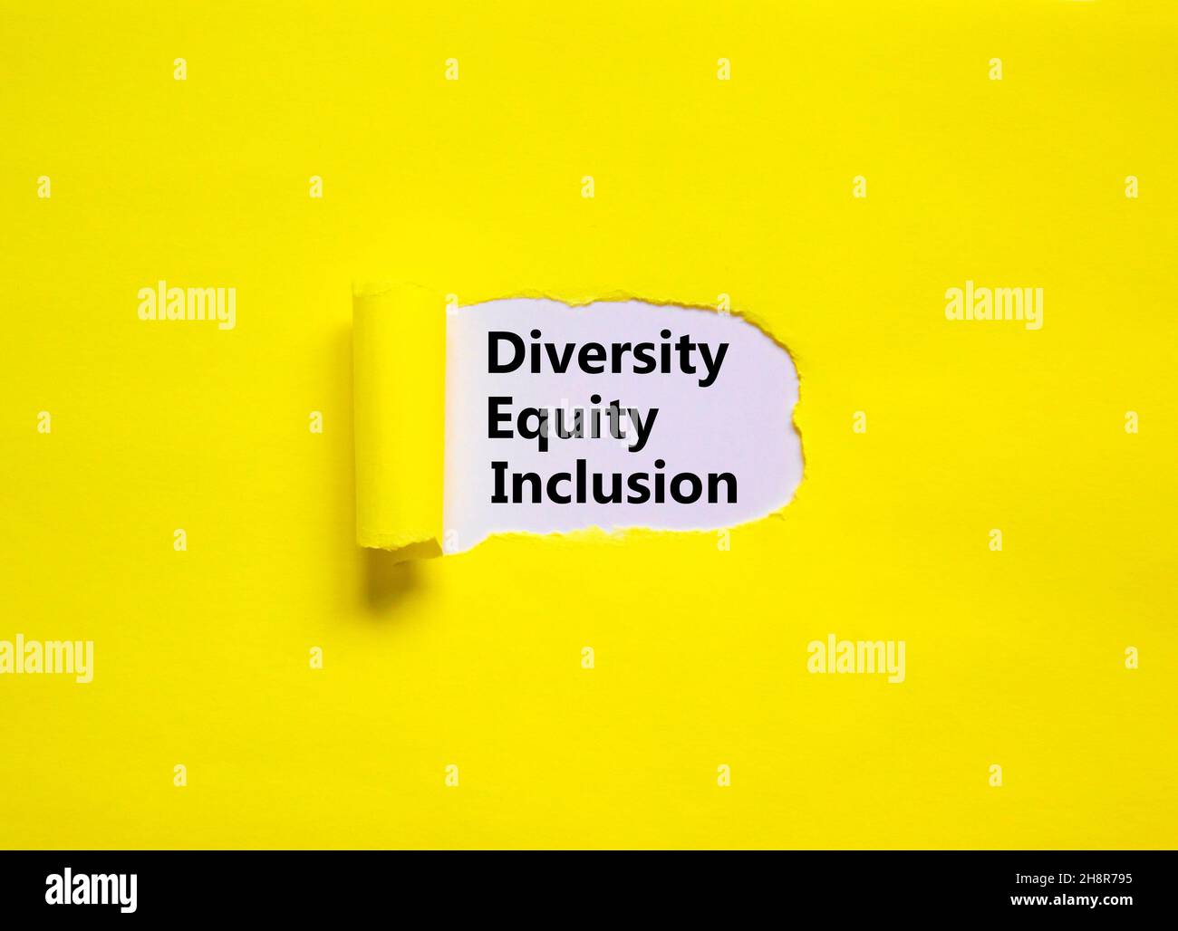 Diversity, equity, inclusion DEI symbol. Words DEI, diversity, equity, inclusion appearing behind torn yellow paper. Pink background. Business, divers Stock Photo