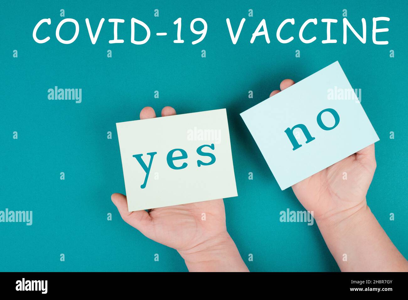 Mandatory vaccination, yes and no is standing on paper, making a decision, covid-19 Stock Photo