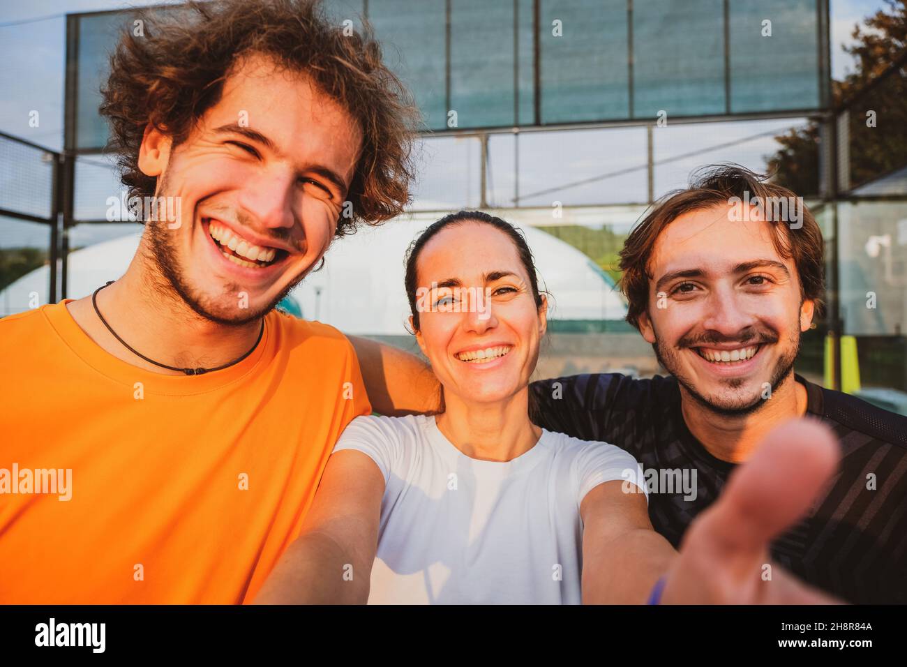 Paddle tennis players smiling and taking selfie with camera after match Stock Photo