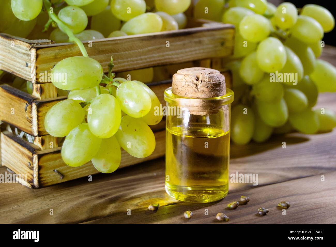 Grape oil seed in small vintage bottle. Heap of grape seeds with green
