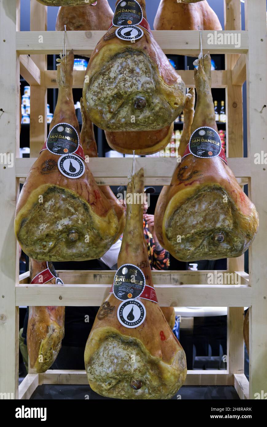 Tuttofood fair, Milan, Italy - 25 october 2021: Italian hams hanging to ripen in a wooden shelf Stock Photo