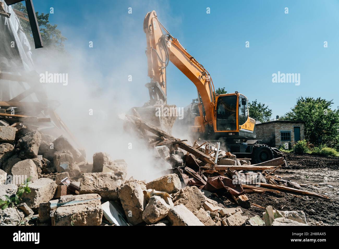 Excavator destroy old house. Demolition of building. Stock Photo