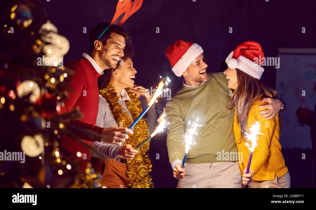 Bonding and party at New Year's eve. A group of friends celebrating New Year's Eve, hugging, and having a party. Stock Photo