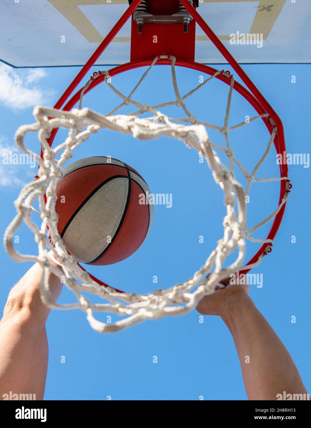 ball goes through basket. man throw the ball in hoop. hands and