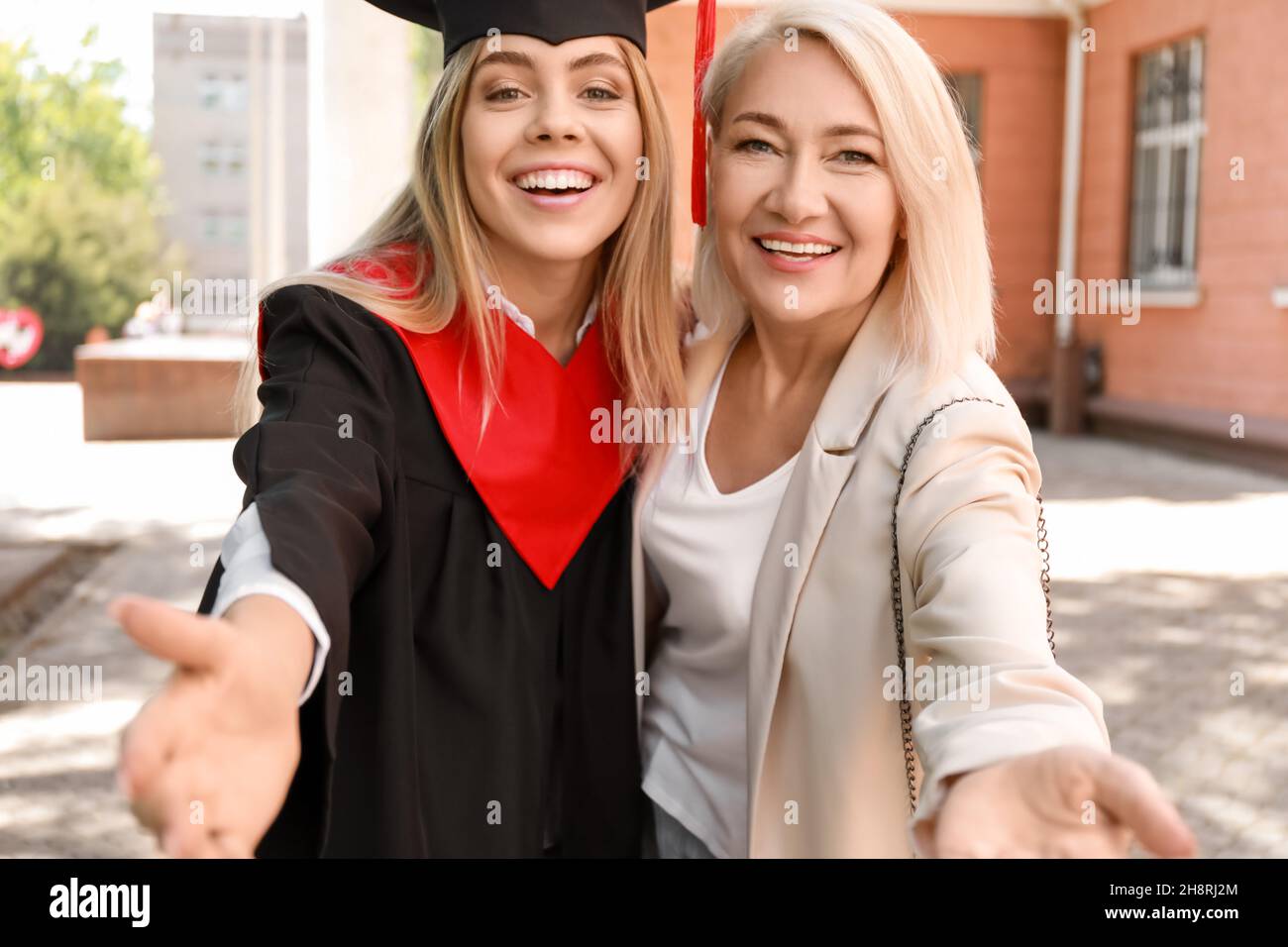 Happy young woman with her mother on graduation day Stock Photo