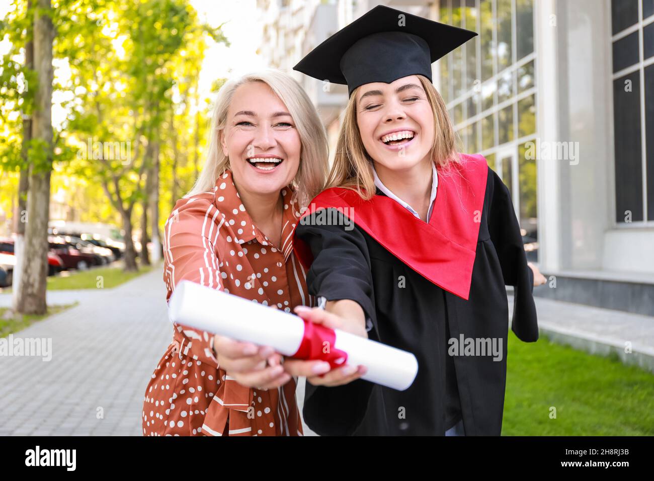 Happy young woman with her mother on graduation day Stock Photo