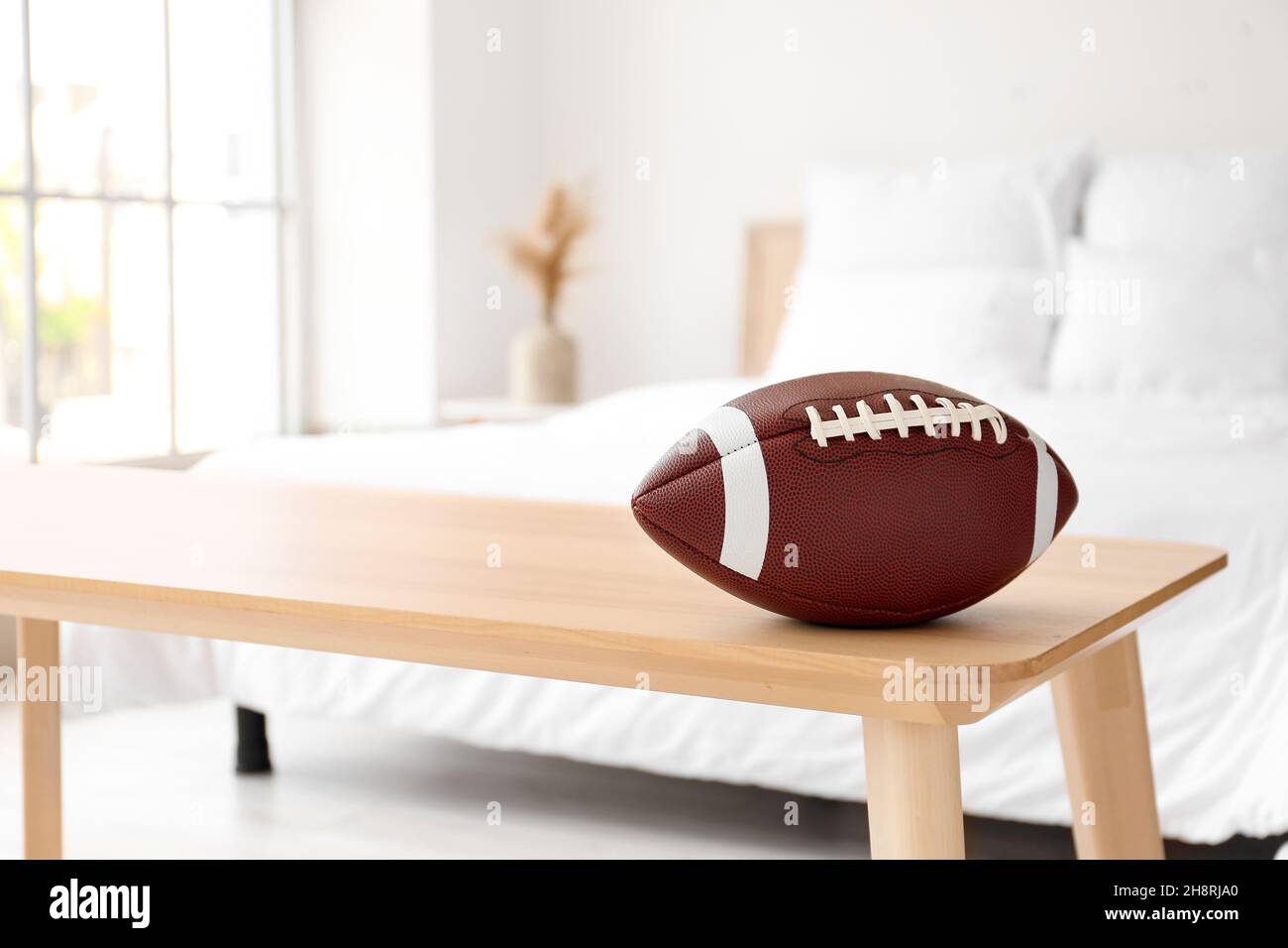 Rugby ball on wooden bench in light bedroom, closeup Stock Photo - Alamy