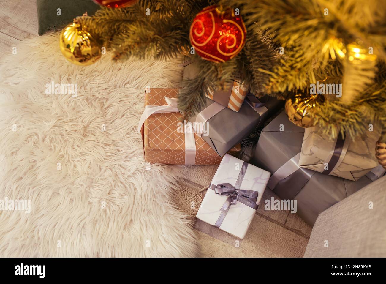 Many gifts under Christmas tree on floor Stock Photo