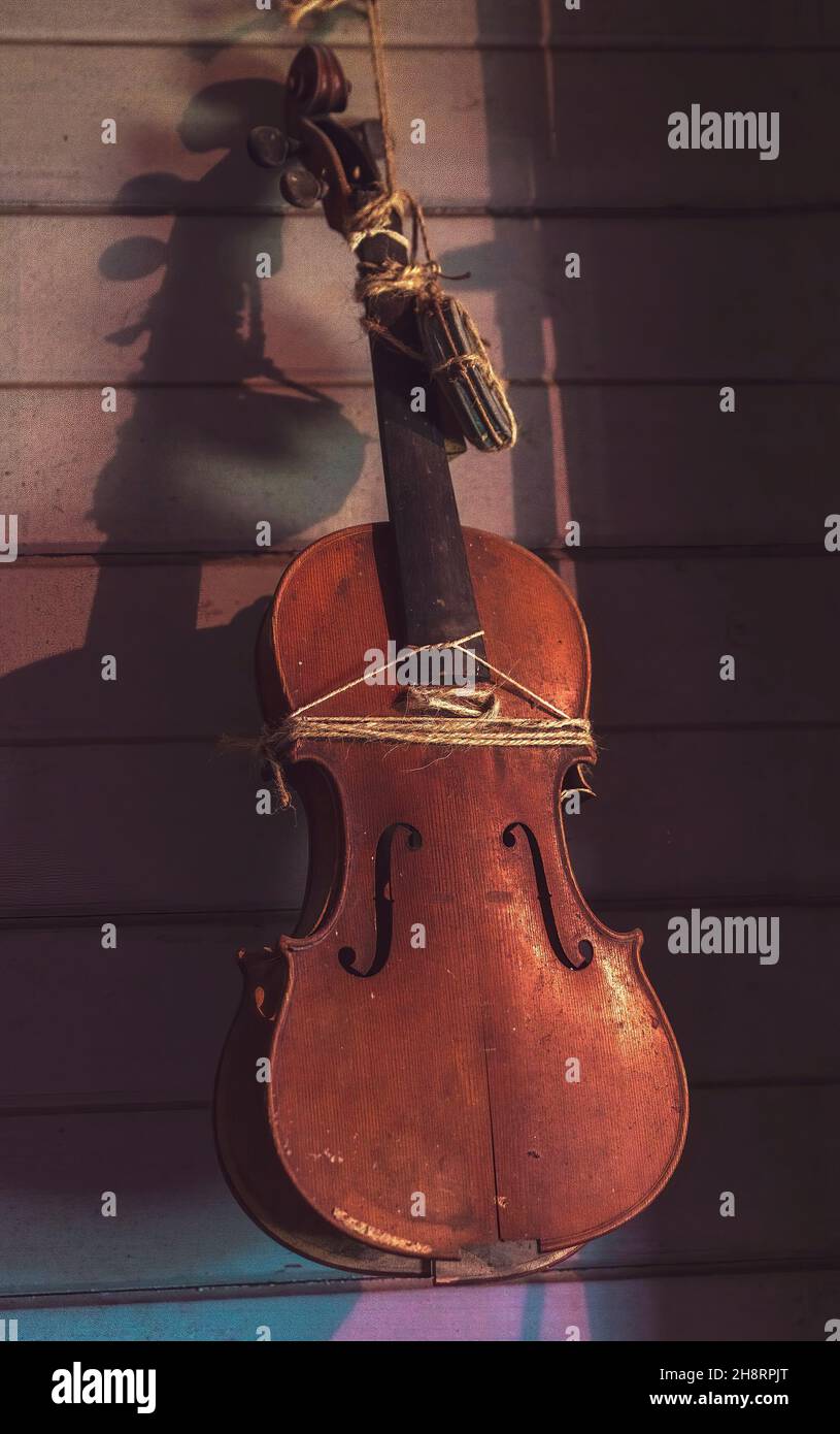 Vintage violin on wall of historical pioneering homestead - grain enhancement to replicate the photography era Stock Photo