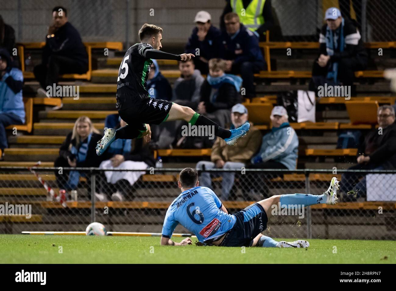 Western United midfielder Luke Duzel (25) jumps over Sydney FC defender Ryan McGowan (6) Stock Photo