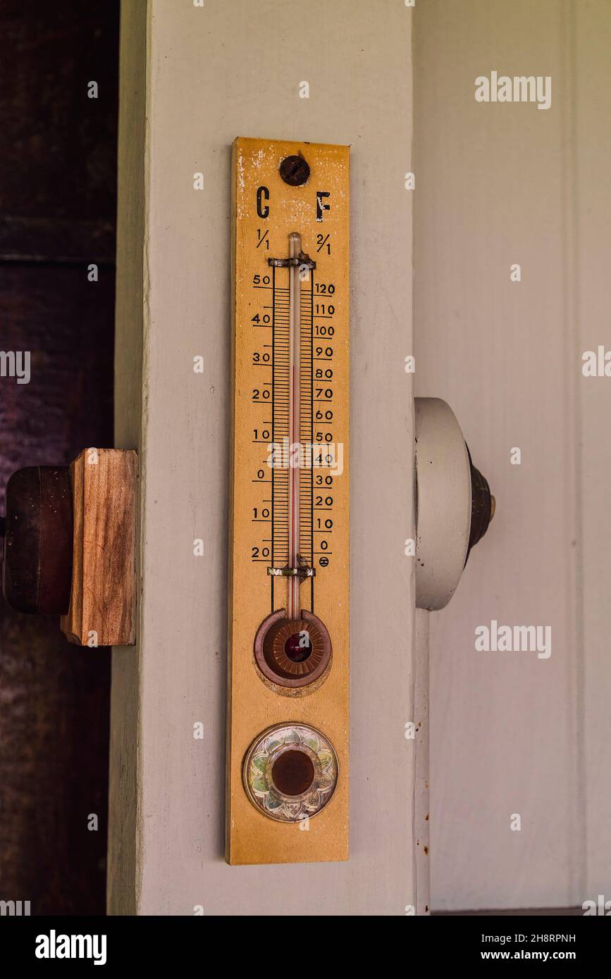 Vintage temperature gauge on wall of historical homestead grain