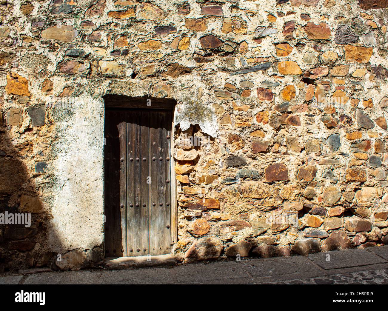 Aged wooden door in a weathered stone wall Stock Photo - Alamy