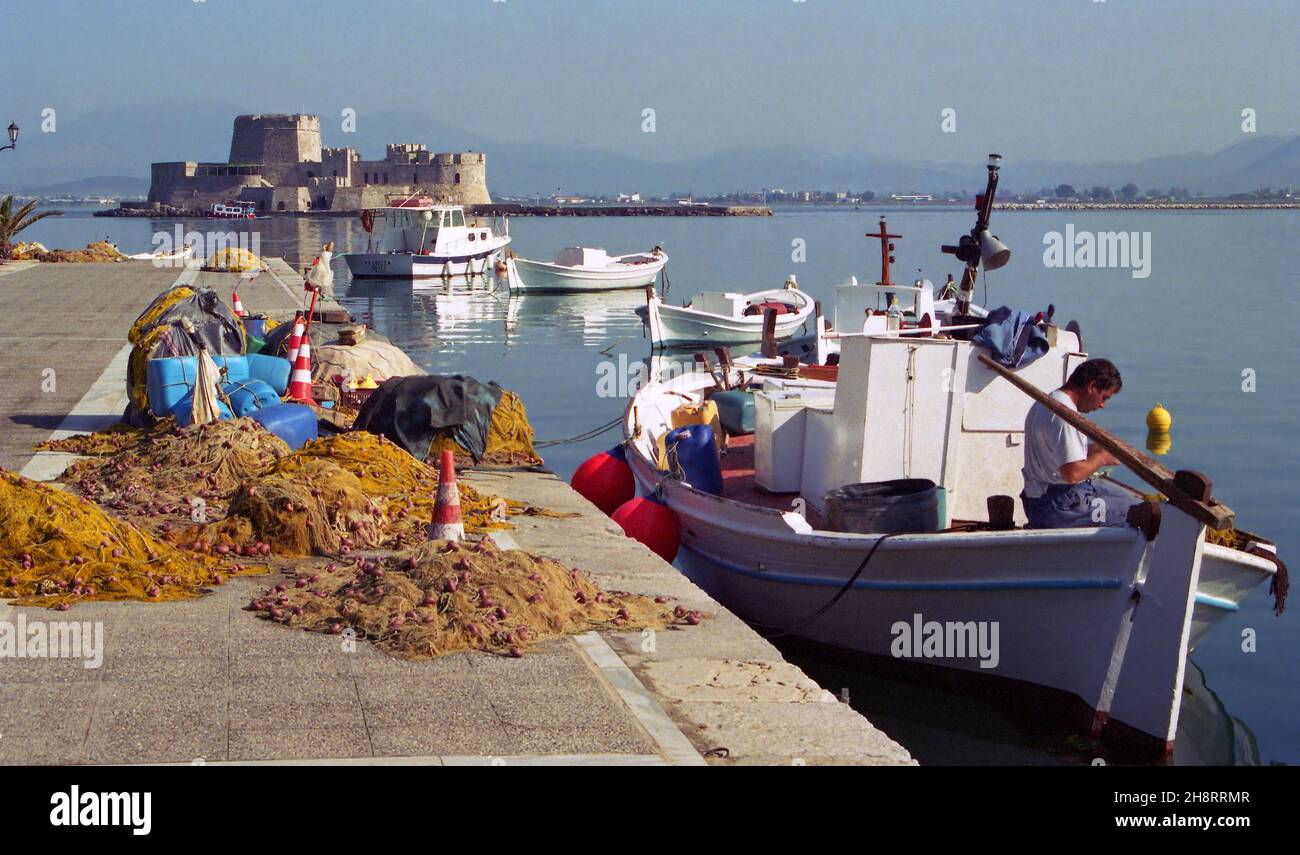 JUN 2005: Bourtzi Castle, fishing boats and fisherman at port of Nafplio (Nafplion or Nauplion) in Greece Stock Photo