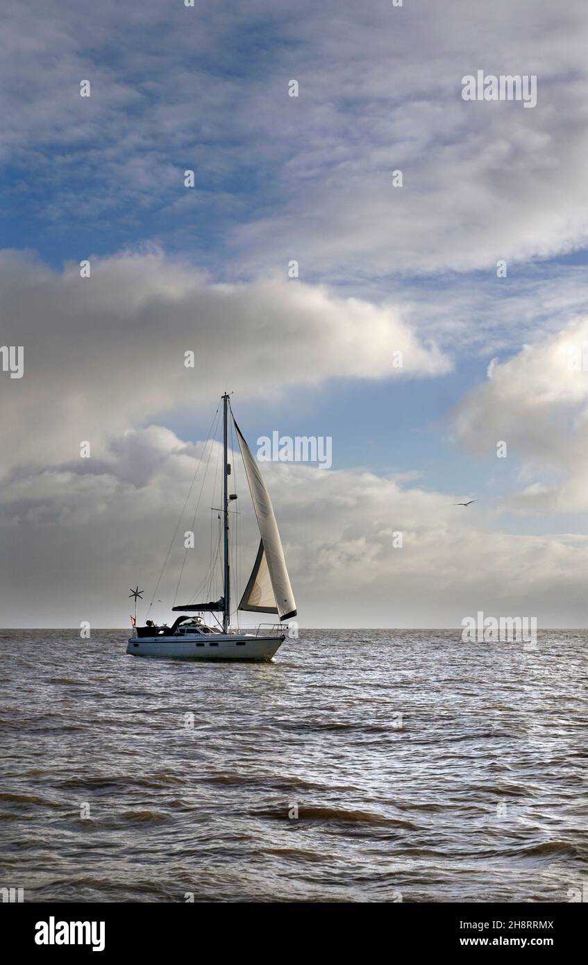 sailing yacht drifting along under jib only in gentle sea off lowestoft suffolk england Stock