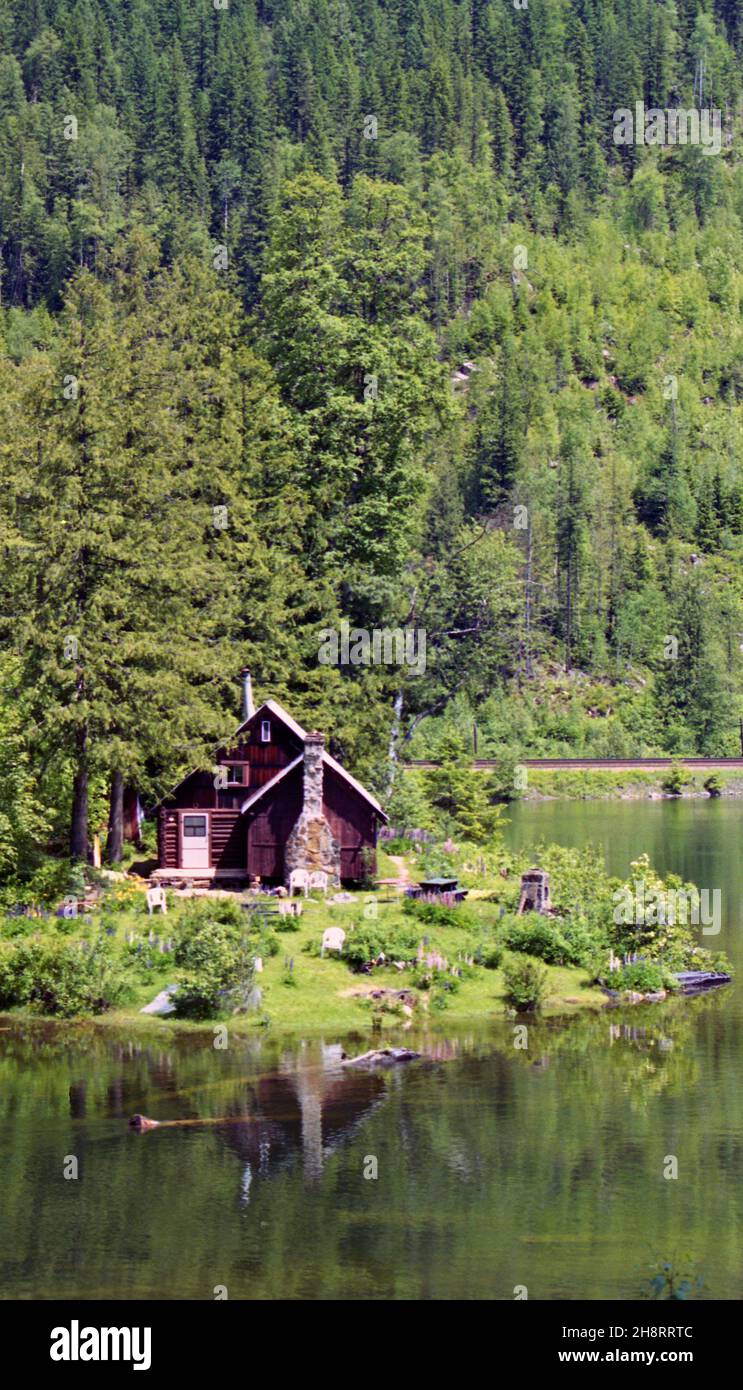 Timber cottage in the forest and reflections on Three Valley Lake near Revelstoke in British Columbia, Canada Stock Photo