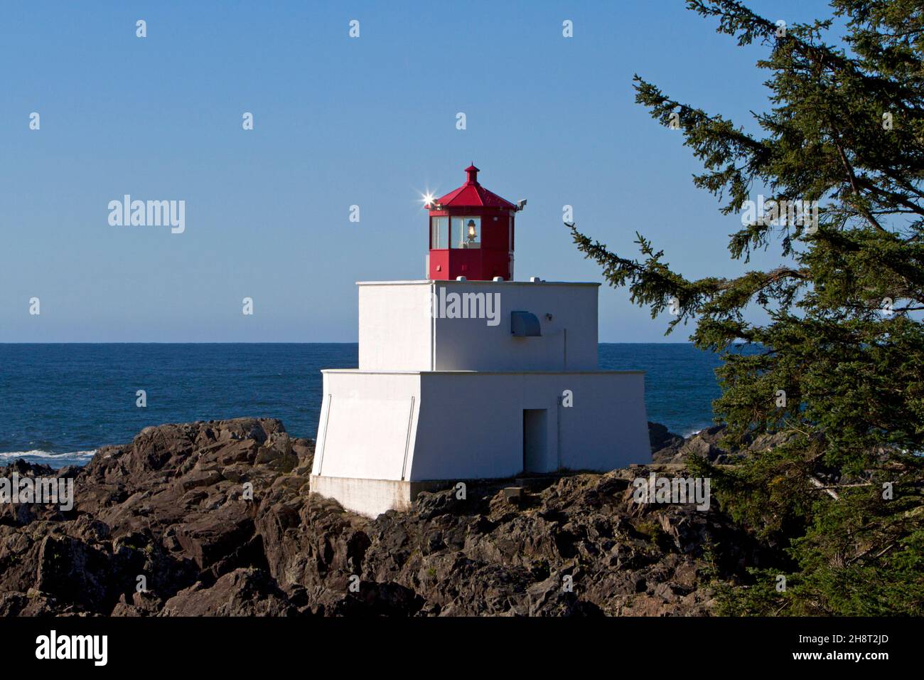 Scenic view of Amphitrite Point lighthouse along the wild pacific trail in Ucluelet, west coast Vancouver Island, BC, Canada with a sun star Stock Photo