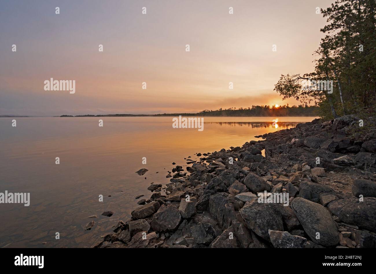 The Sun Rising Onto Calm Waters in the Morning on Saganaga Lake in the Boundary Waters in Minnesota Stock Photo